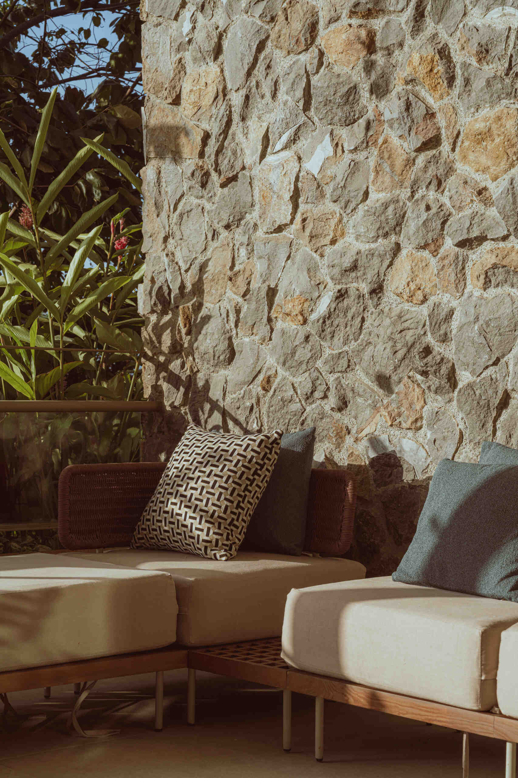 This bedroom with a stone wall opens to a private patio.