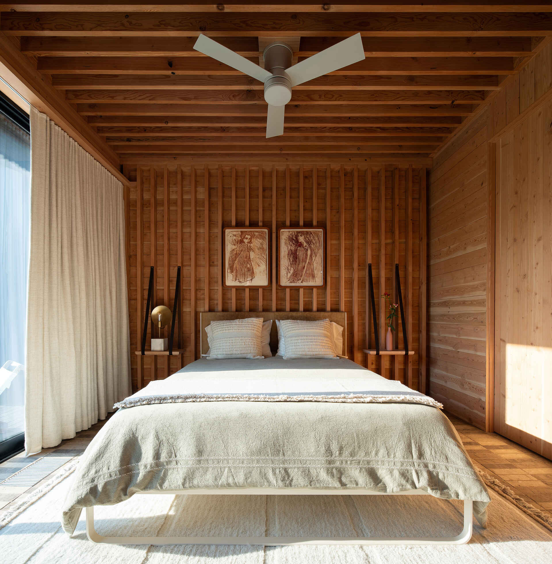 Tranquil bedrooms lined in exposed wood, where restraint and texture replace ornamentation for a calm, grounded atmosphere.