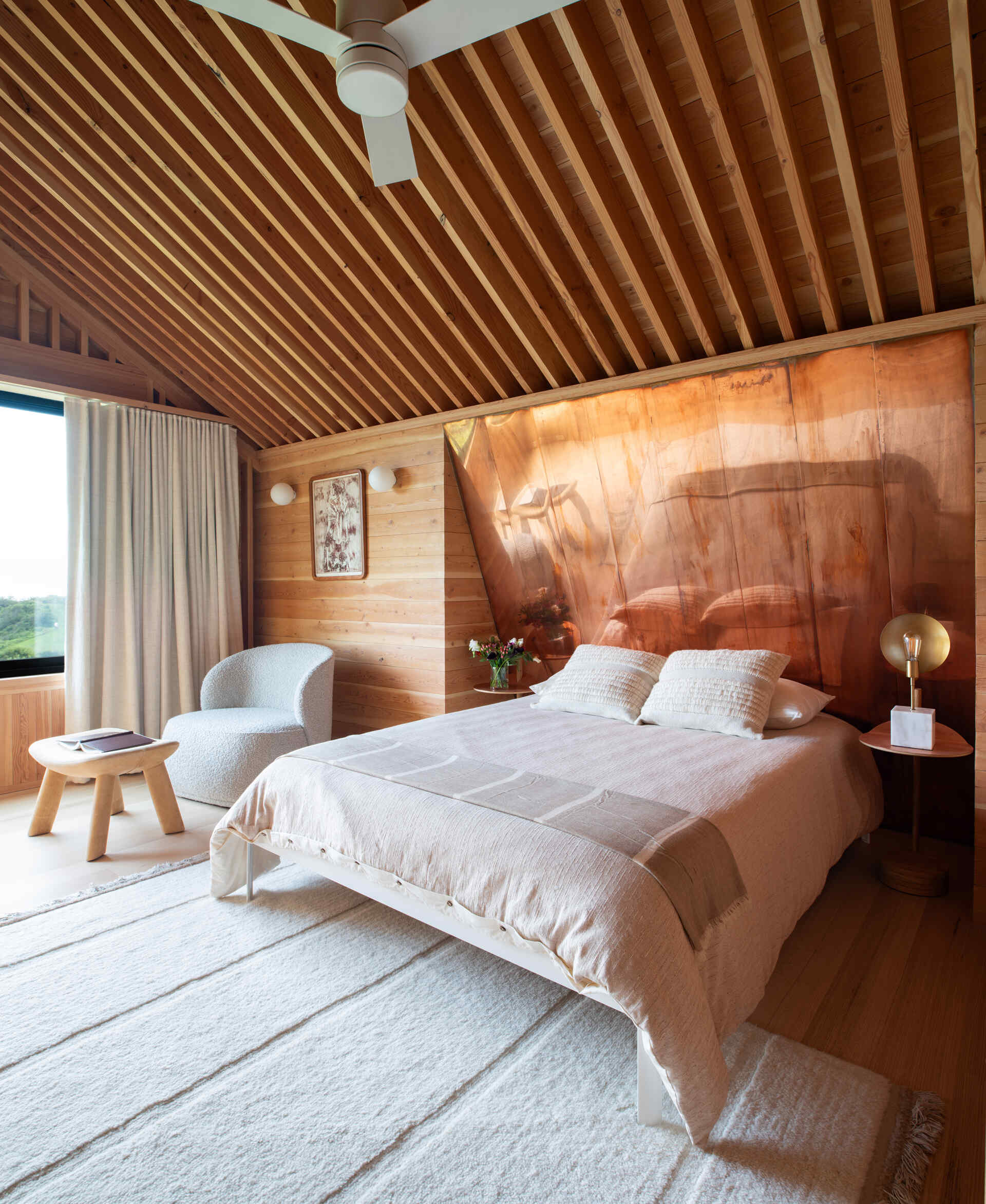 Tranquil bedrooms lined in exposed wood, where restraint and texture replace ornamentation for a calm, grounded atmosphere.