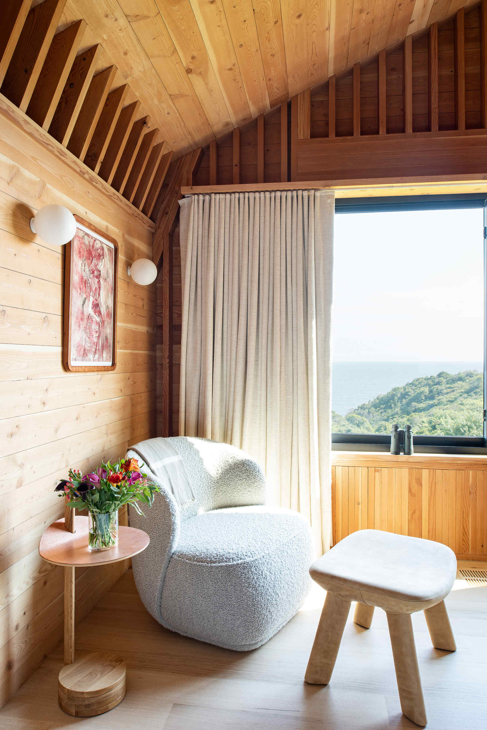 Tranquil bedrooms lined in exposed wood, where restraint and texture replace ornamentation for a calm, grounded atmosphere.