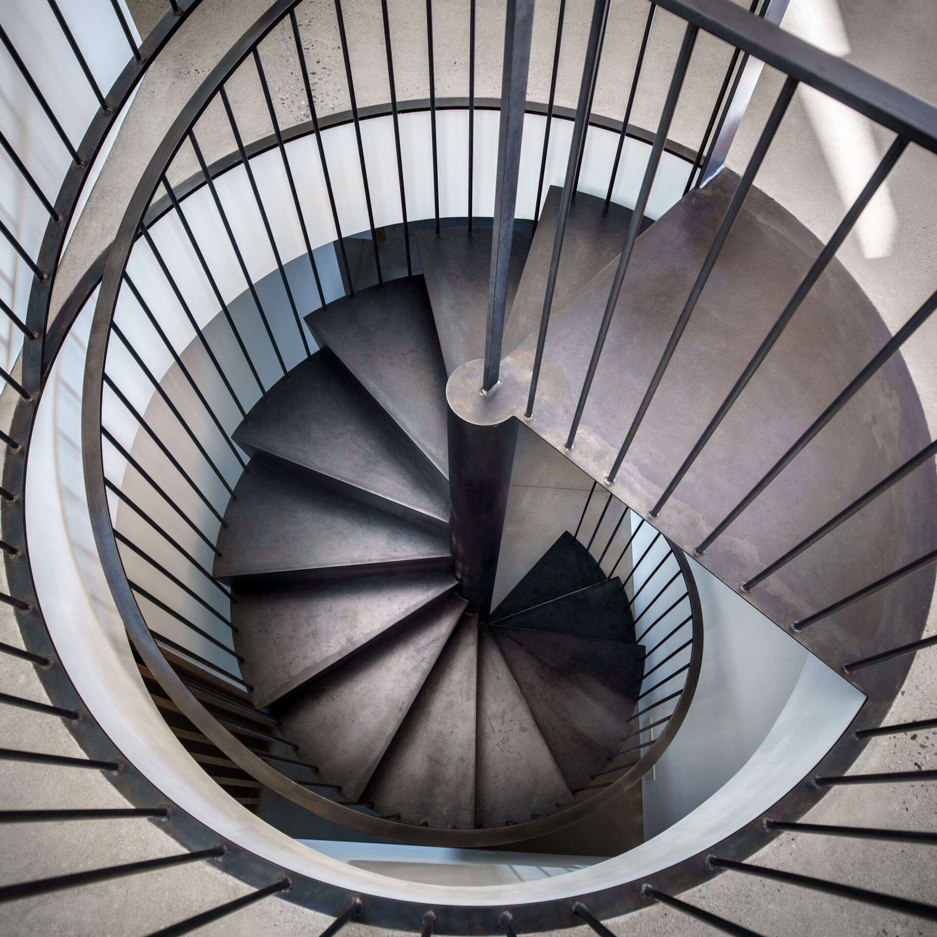 A custom steel spiral staircase saves space while adding a sculptural moment between levels.