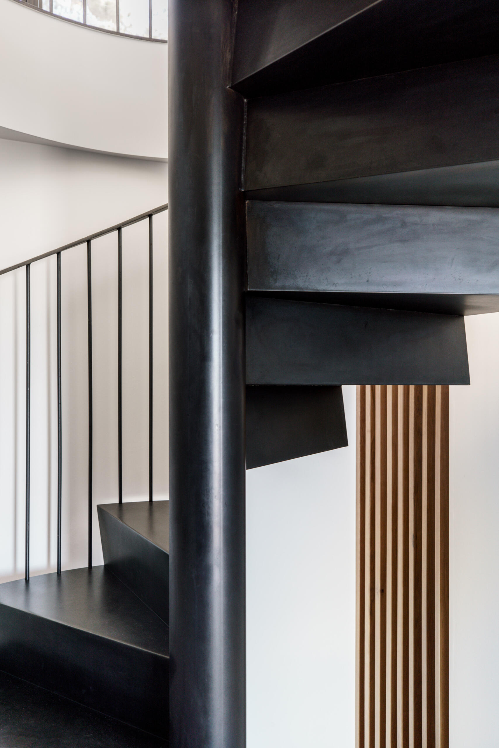 A custom steel spiral staircase saves space while adding a sculptural moment between levels.