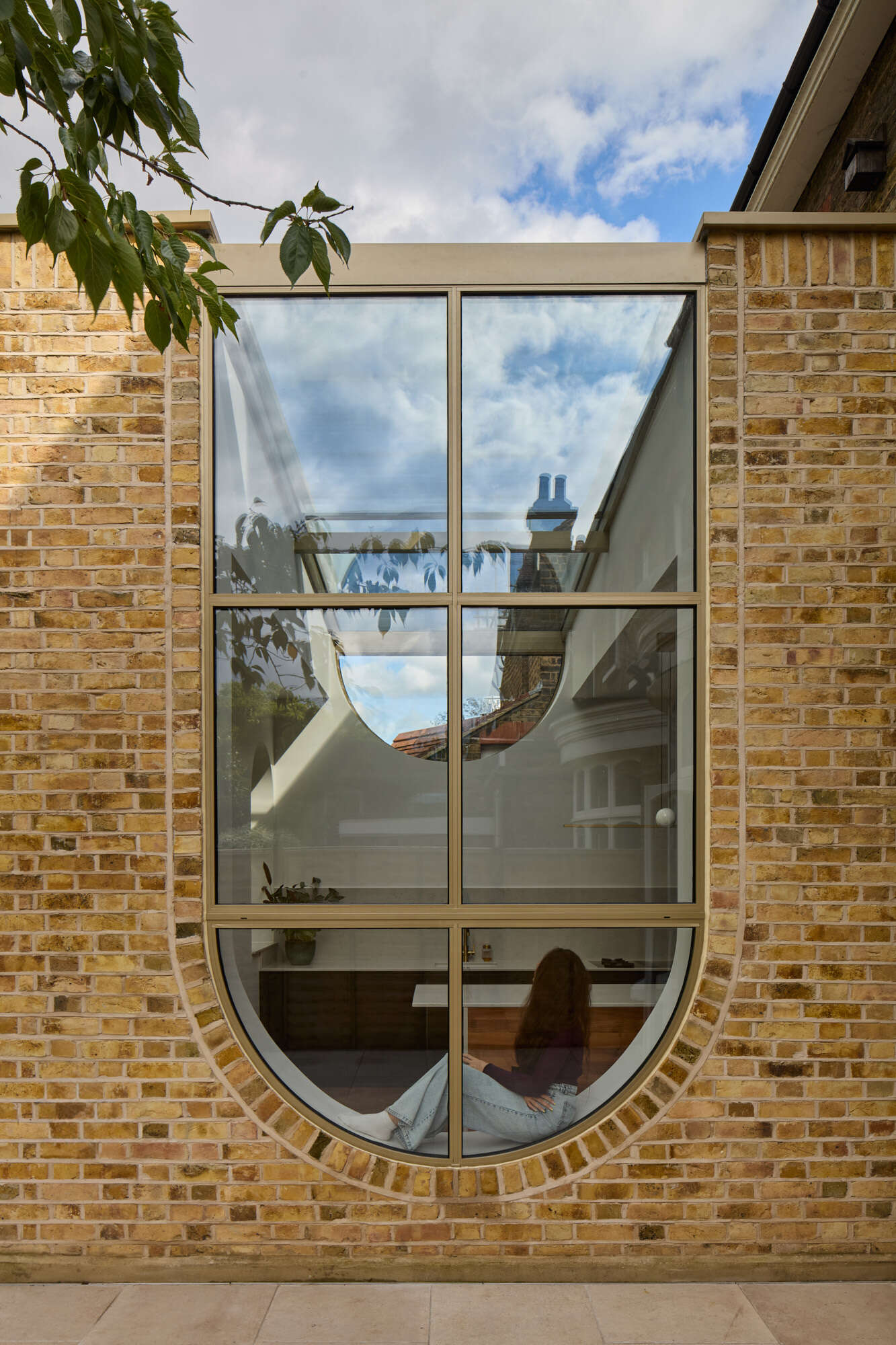 This rear extension of Perry Vale House reinterprets Edwardian craftsmanship with playful arches, reclaimed yellow London Stock Brick, and metallic bronze framing.