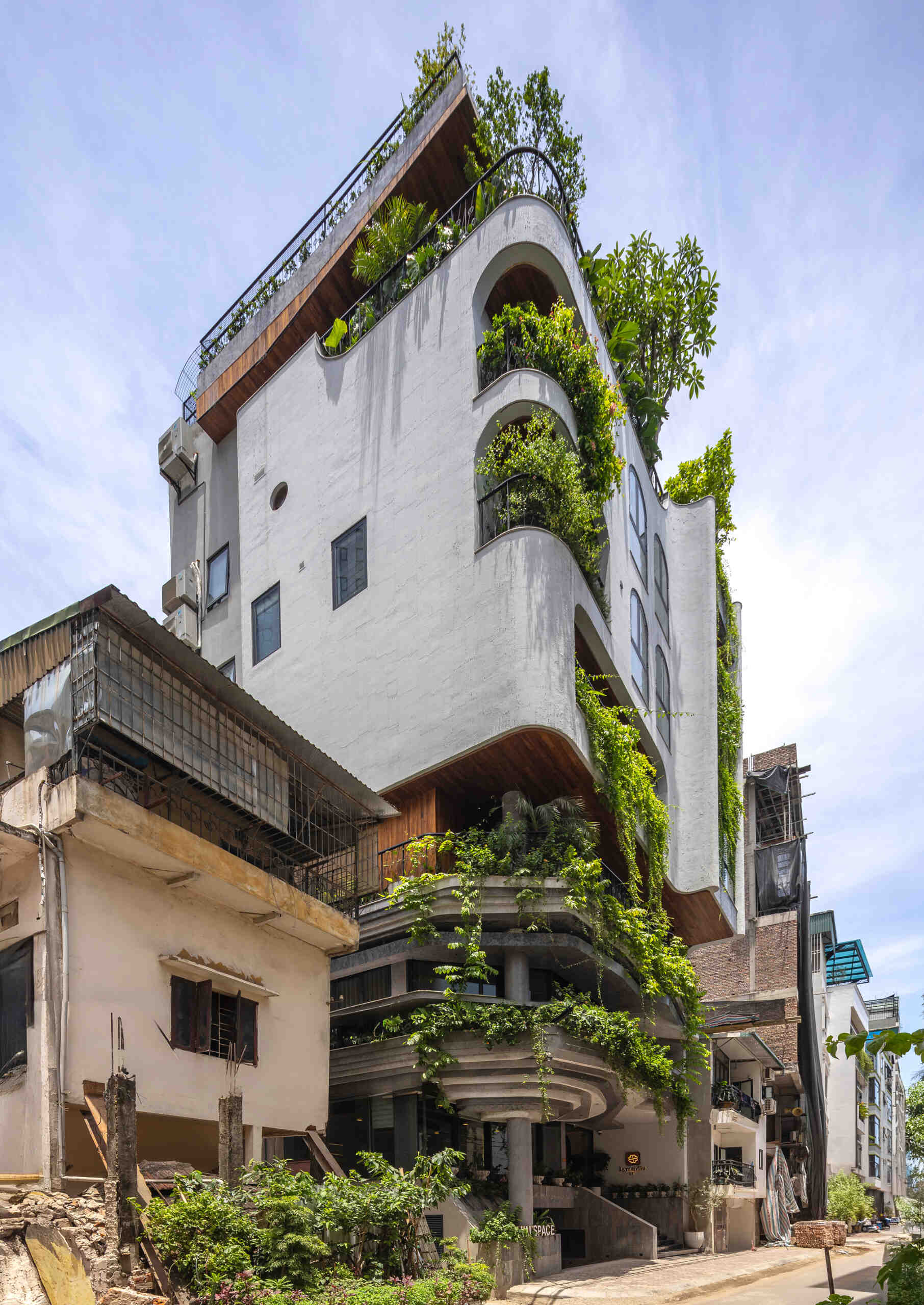 A serene, story-driven building in Hanoi that blends a bold vertical core with soft greenery, natural light, and gentle architectural rhythms to express resilience and quiet elegance in the city.