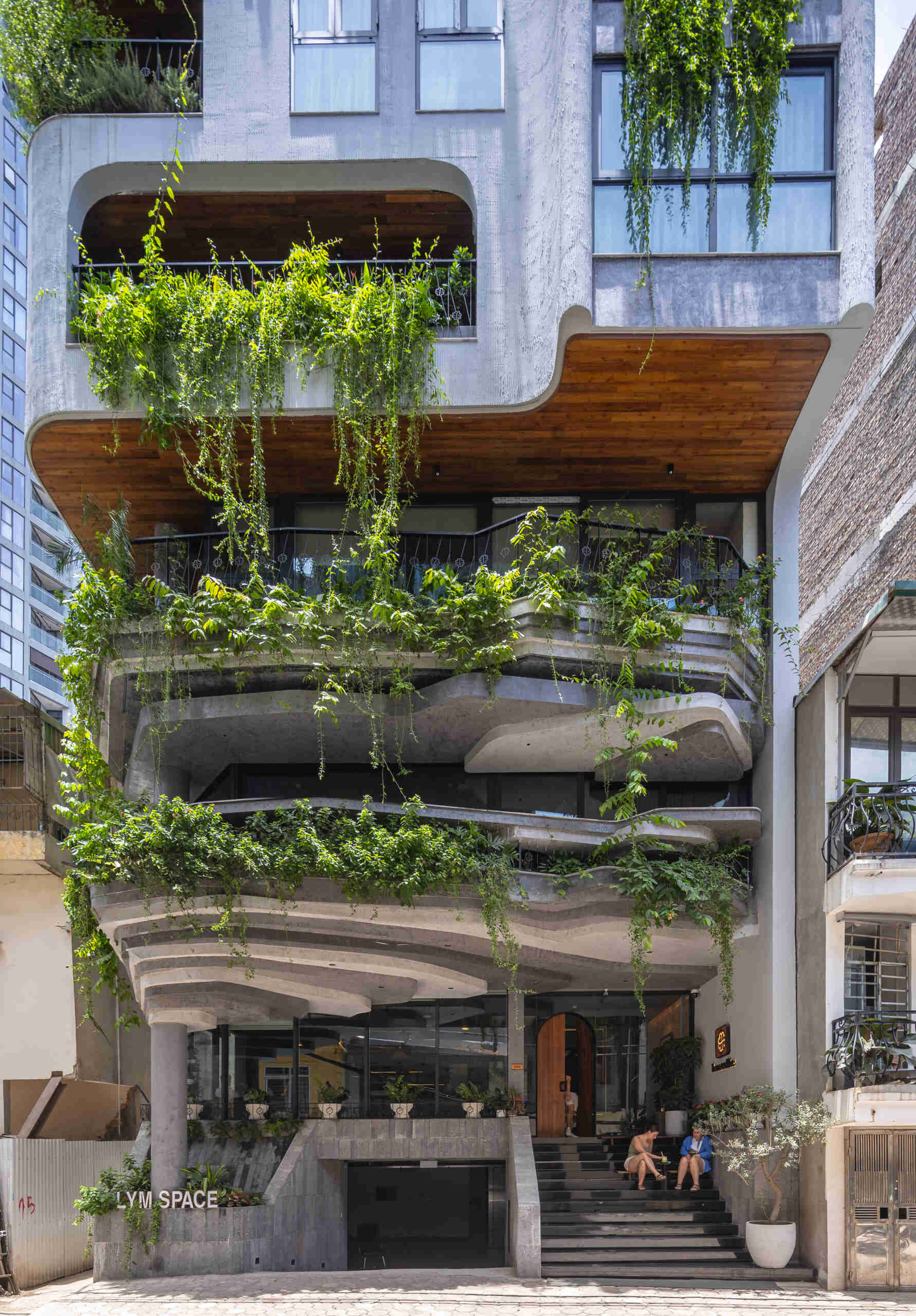 A serene, story-driven building in Hanoi that blends a bold vertical core with soft greenery, natural light, and gentle architectural rhythms to express resilience and quiet elegance in the city.