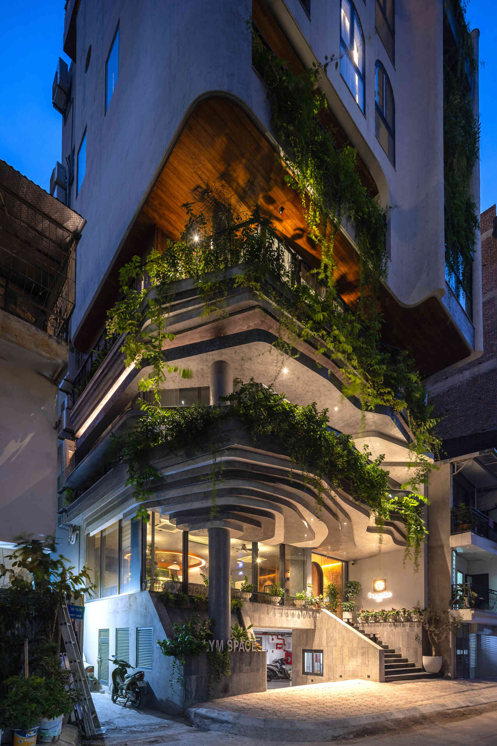 A serene, story-driven building in Hanoi that blends a bold vertical core with soft greenery, natural light, and gentle architectural rhythms to express resilience and quiet elegance in the city.