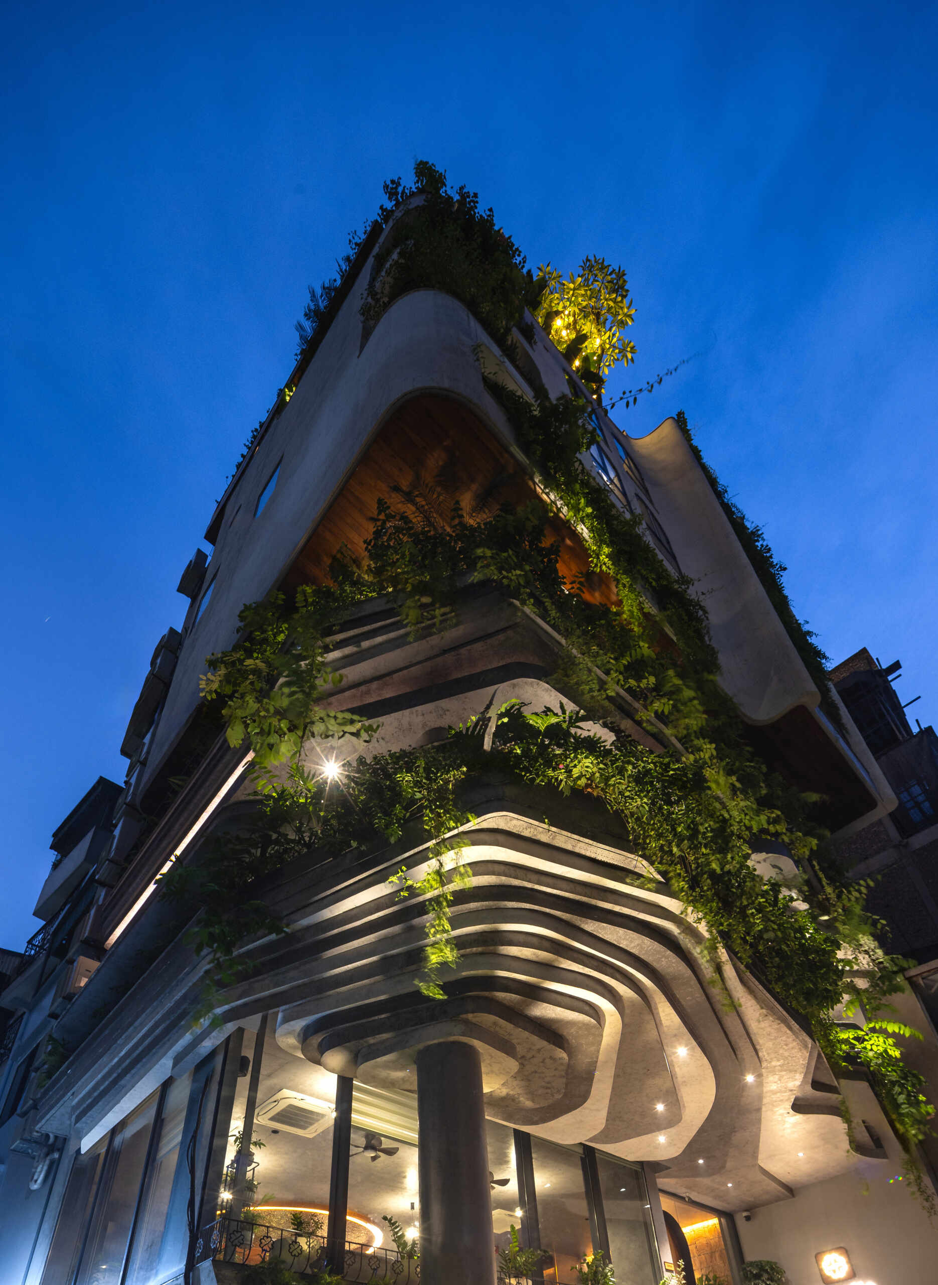 A serene, story-driven building in Hanoi that blends a bold vertical core with soft greenery, natural light, and gentle architectural rhythms to express resilience and quiet elegance in the city.