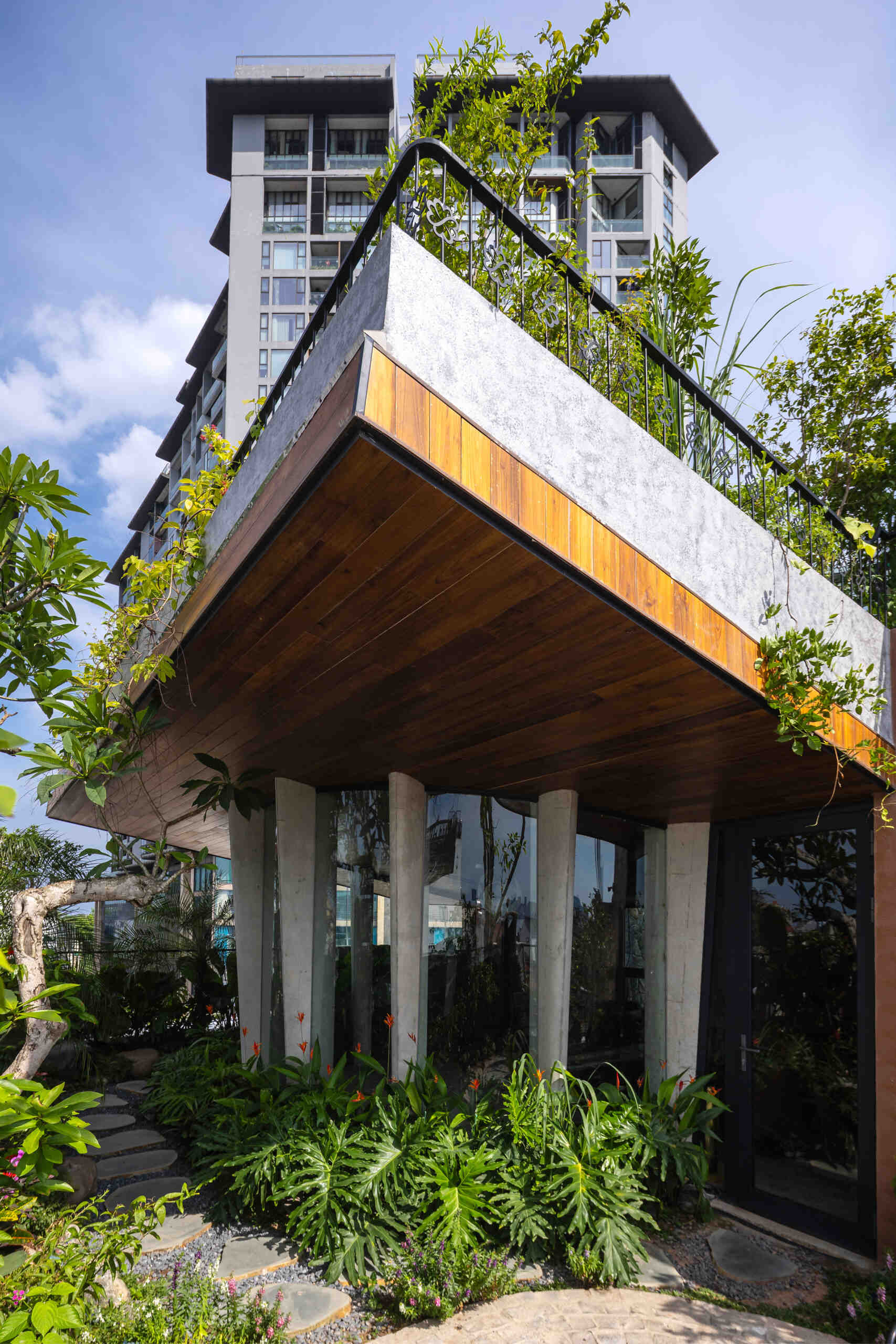 A serene, story-driven building in Hanoi that blends a bold vertical core with soft greenery, natural light, and gentle architectural rhythms to express resilience and quiet elegance in the city.