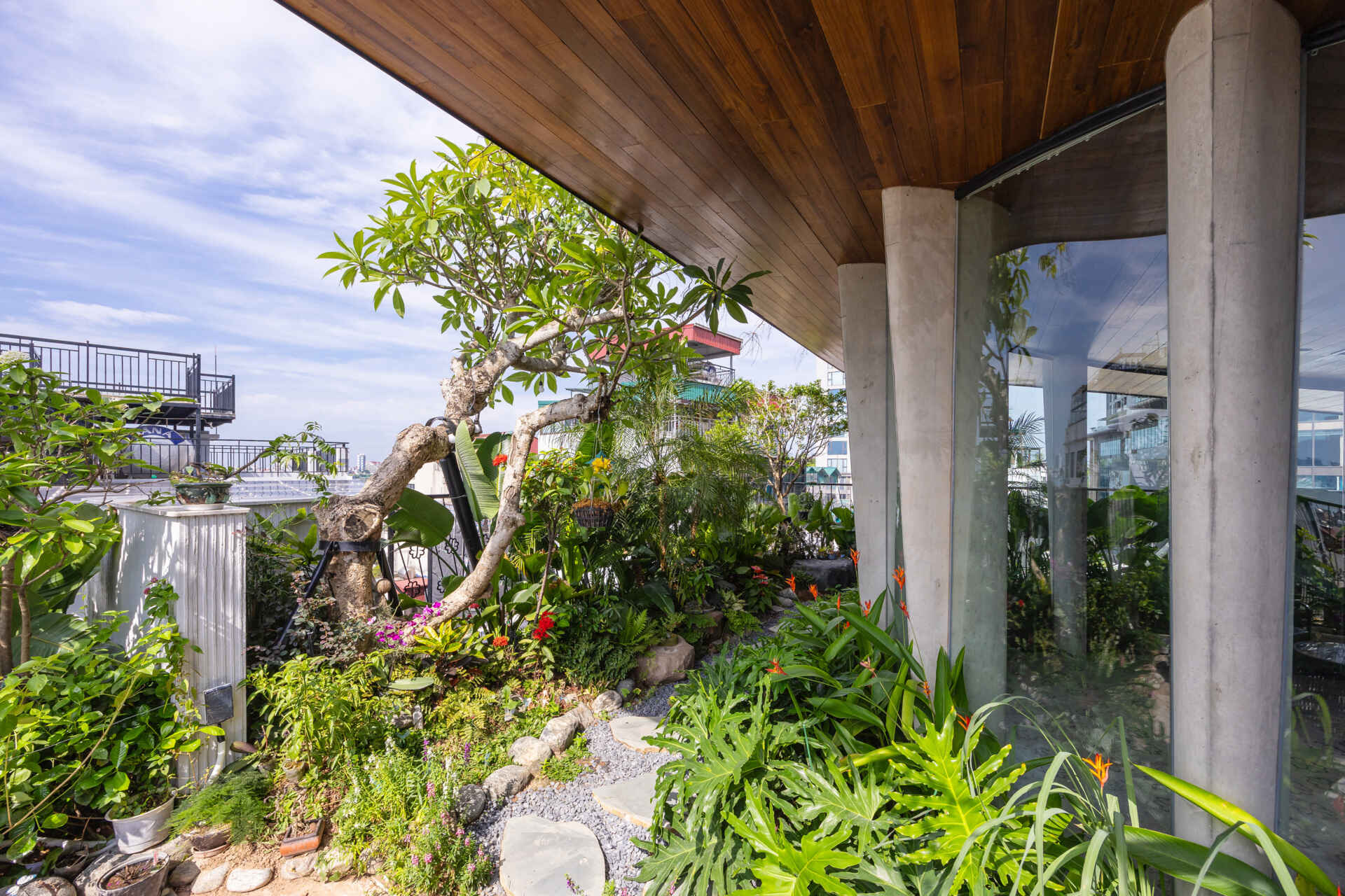 A serene, story-driven building in Hanoi that blends a bold vertical core with soft greenery, natural light, and gentle architectural rhythms to express resilience and quiet elegance in the city.
