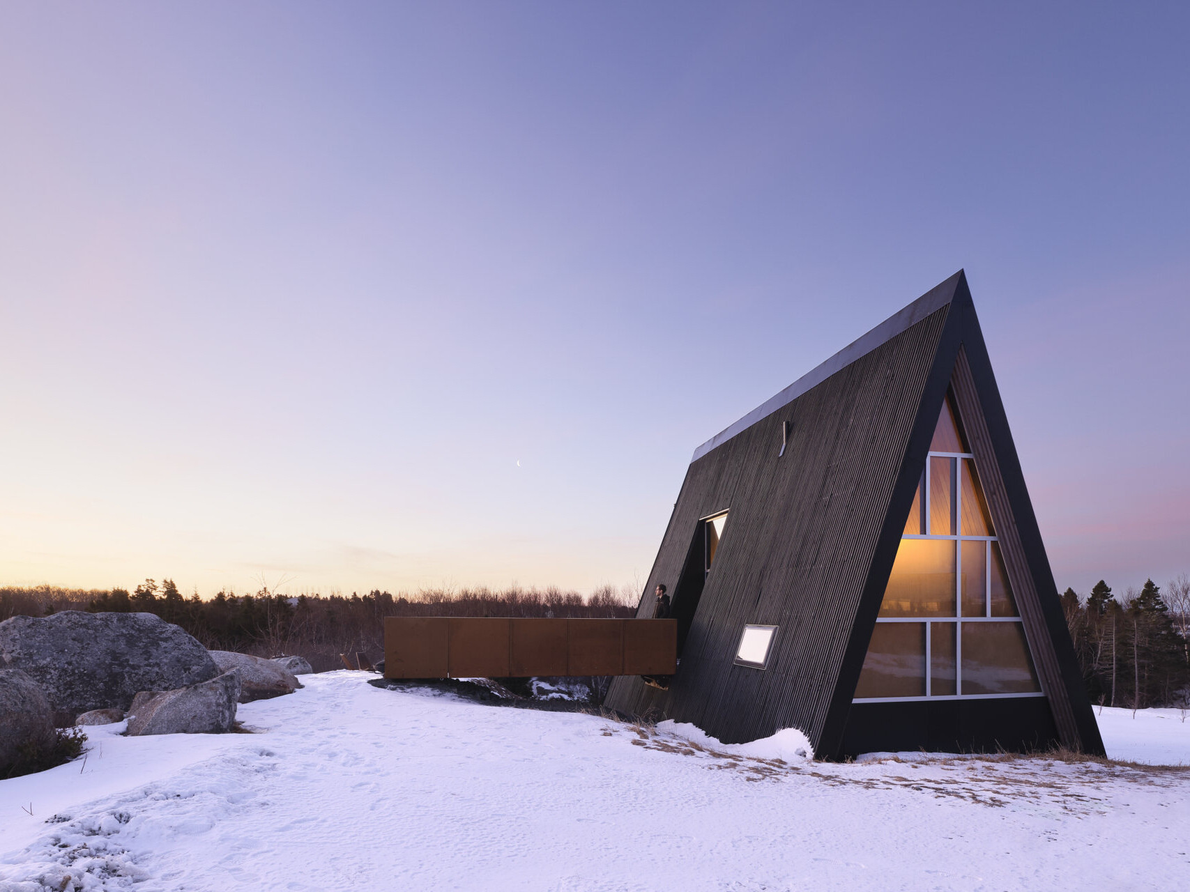 This B Frame cottage rises from bedrock with warm white oak interiors and polished concrete floors.
