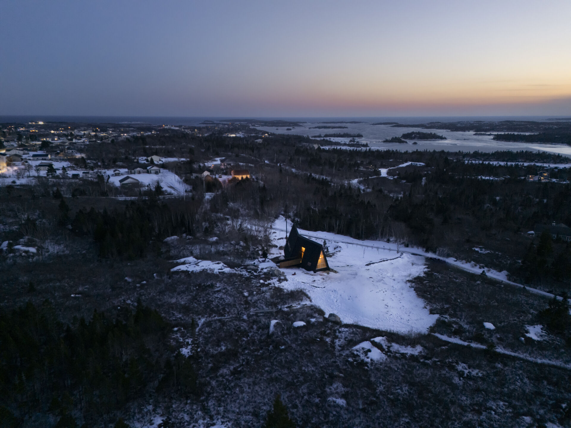 This B Frame cottage rises from bedrock with warm white oak interiors and polished concrete floors.