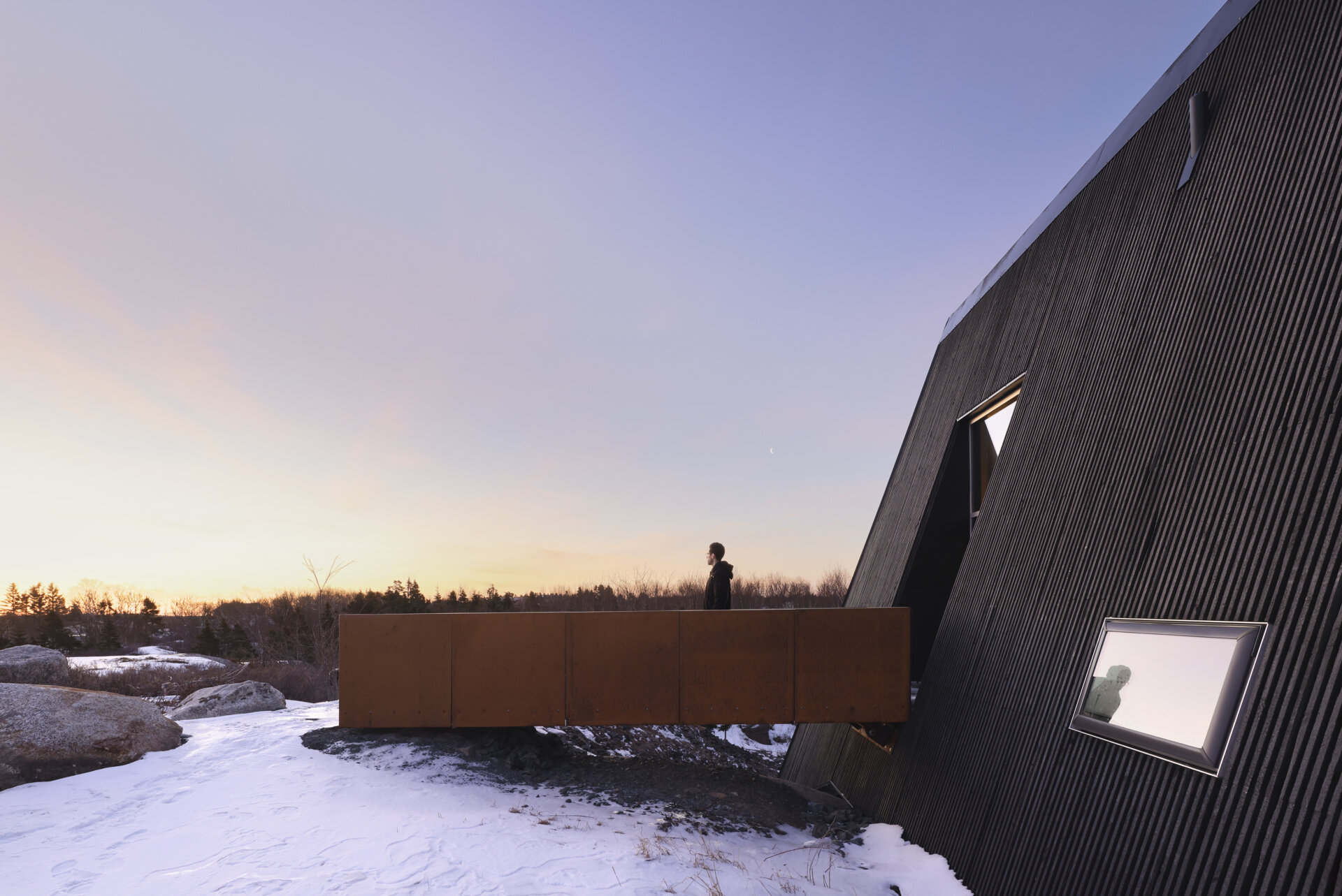 This B Frame cottage rises from bedrock with warm white oak interiors and polished concrete floors.