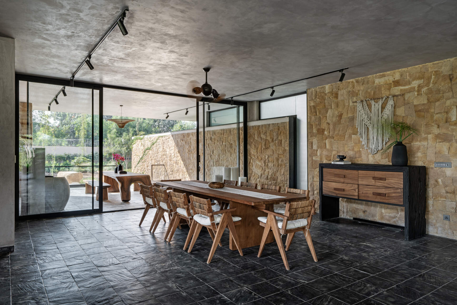 The dining space sits along the central axis of the home, visually connected to the outdoors via large sliding glass doors, providing views of  the lawns making everyday meals feel open and connected to the landscape.