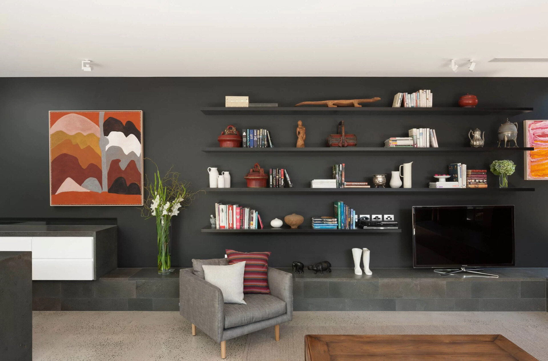 A stepped bluestone mass sits between the public and private areas, screening the living spaces from the entry and defining two internal courtyards. This stone element acts like a monolithic feature that can be experienced from all sides. Inside, it transforms into a seat, a hearth, a bookcase and even part of the kitchen.