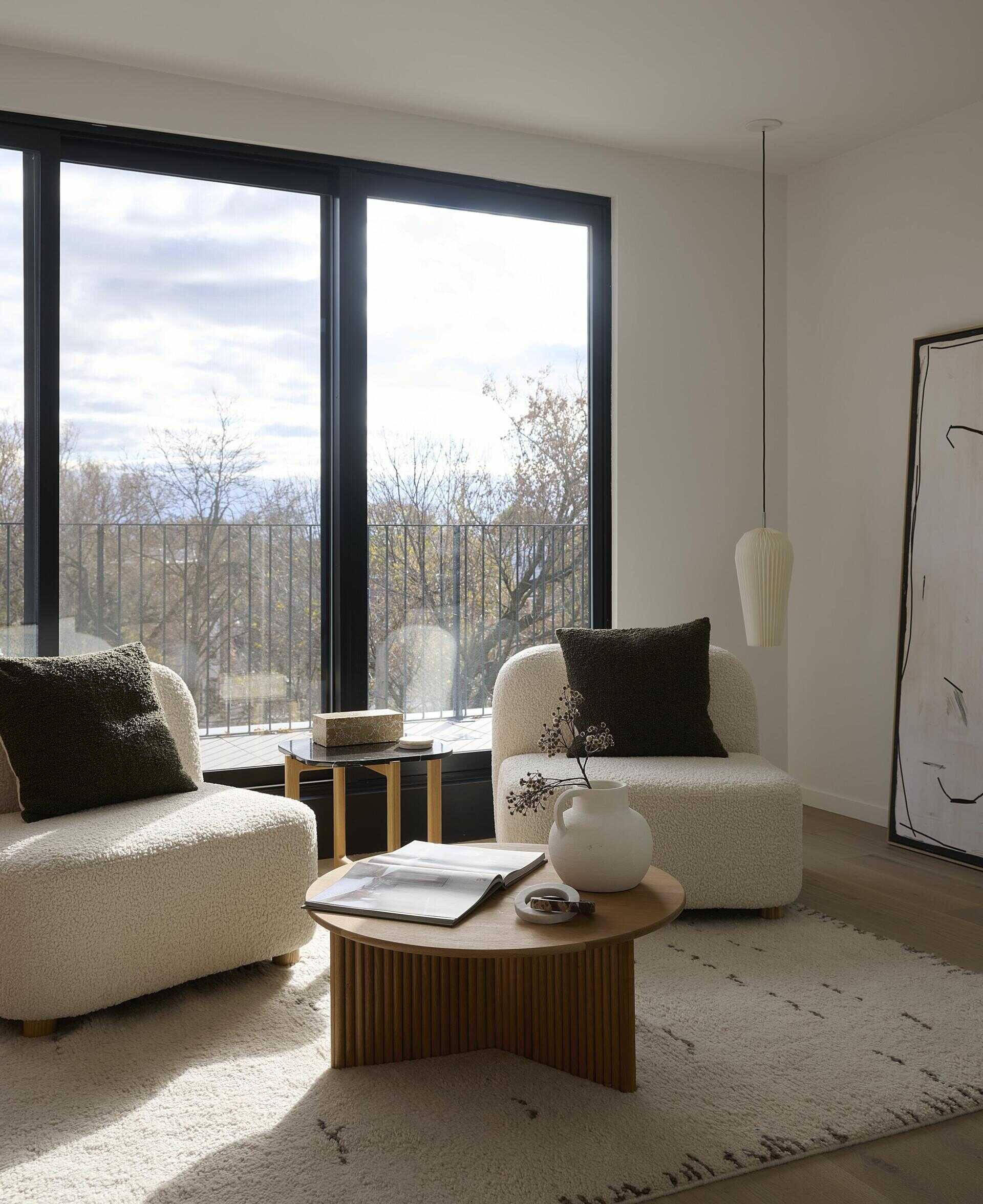 At the top of the home, a family room connects to the rooftop deck through a full glass wall, while a deep burgundy bar anchors the space, giving weight to the open view and complementing the calm interior palette.