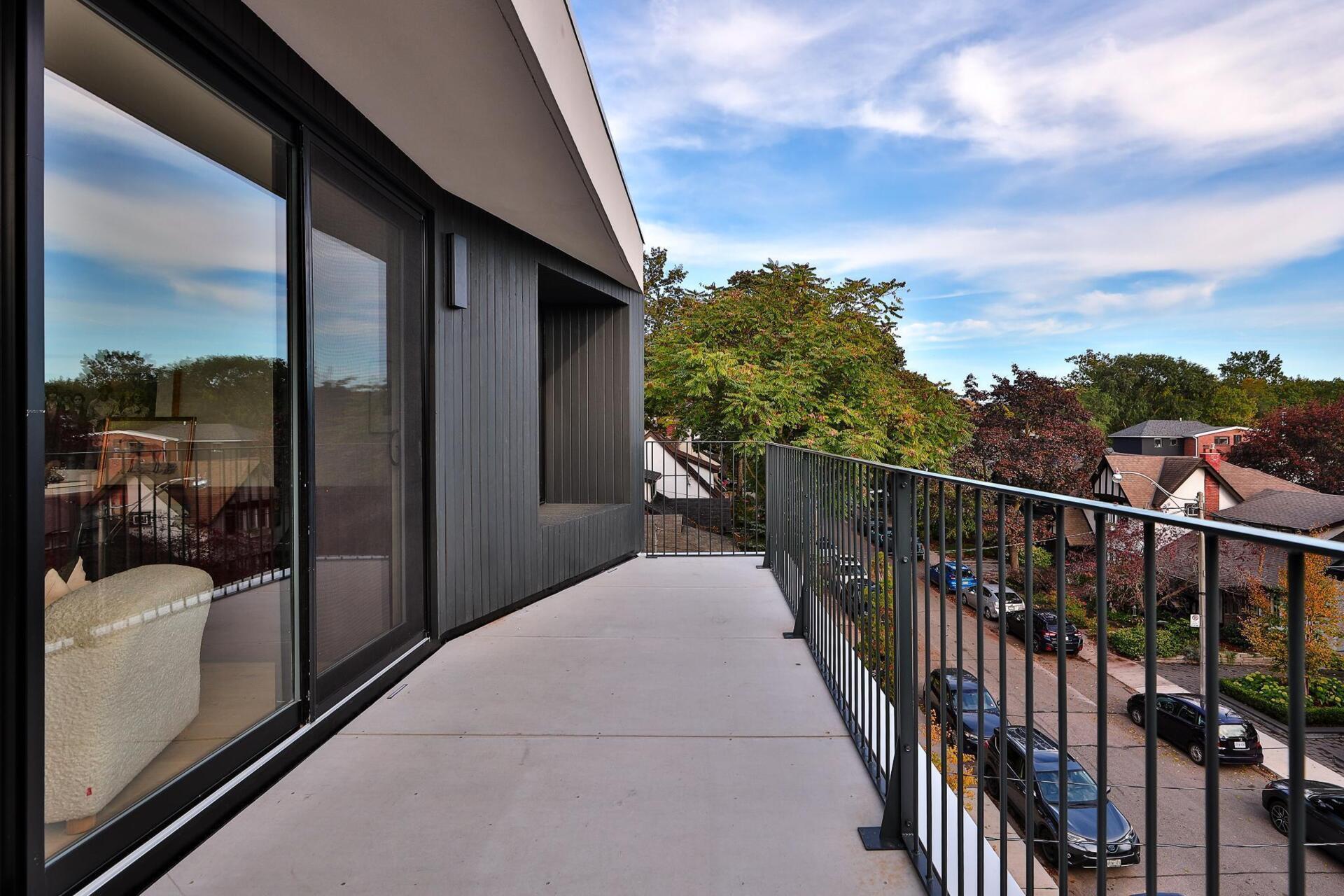 At the top of the home, a family room connects to the rooftop deck through a full glass wall, while a deep burgundy bar anchors the space, giving weight to the open view and complementing the calm interior palette.