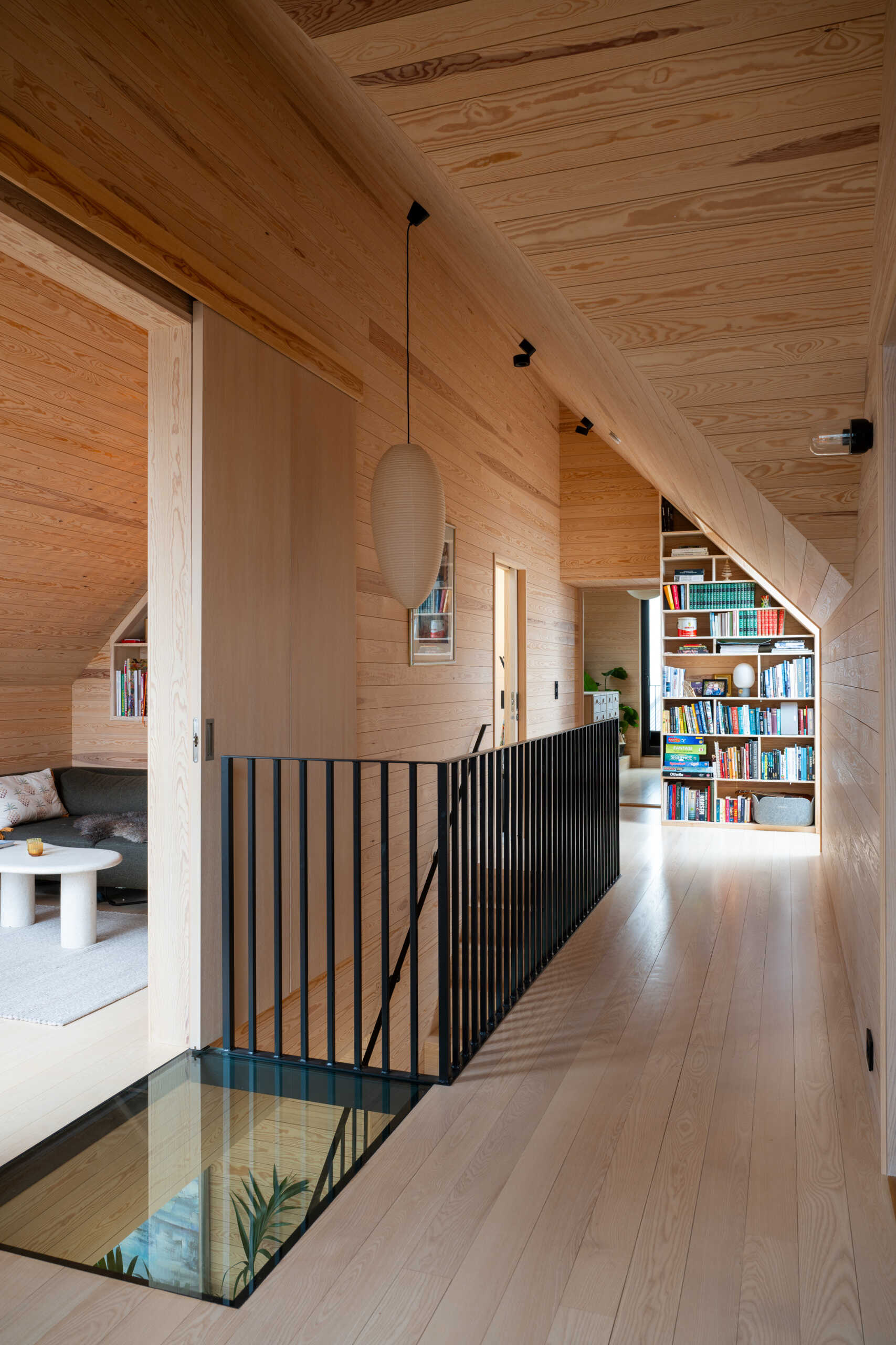 A solid timber staircase links the floors with understated elegance. It reflects the home’s focus on durable materials, tactile surfaces, and functional design, contributing to the overall sense of harmony and quality. A glass section of flooring offers views to the lower level, and at the same time, allows light to travel freely.