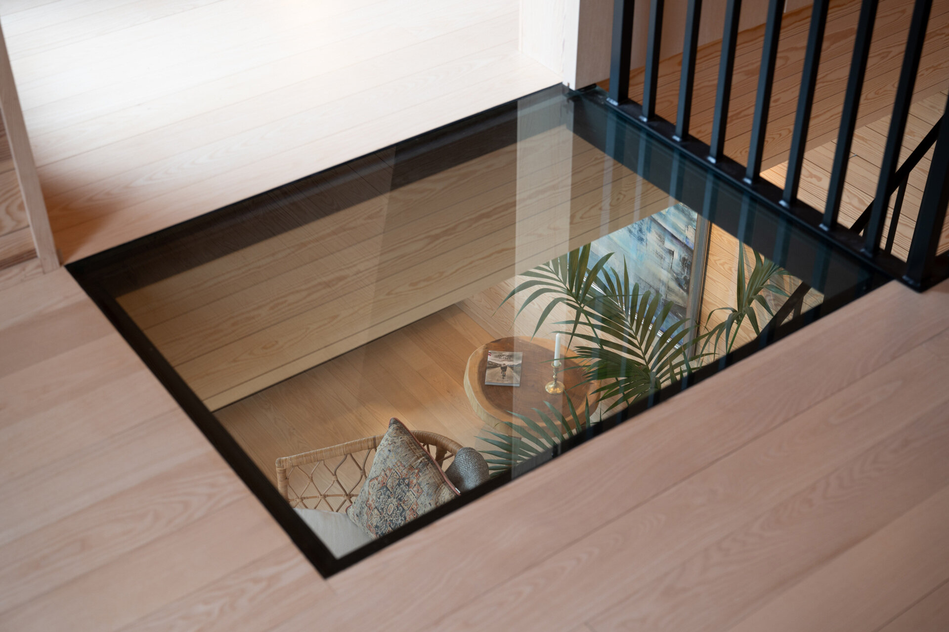 A solid timber staircase links the floors with understated elegance. It reflects the home’s focus on durable materials, tactile surfaces, and functional design, contributing to the overall sense of harmony and quality. A glass section of flooring offers views to the lower level, and at the same time, allows light to travel freely.