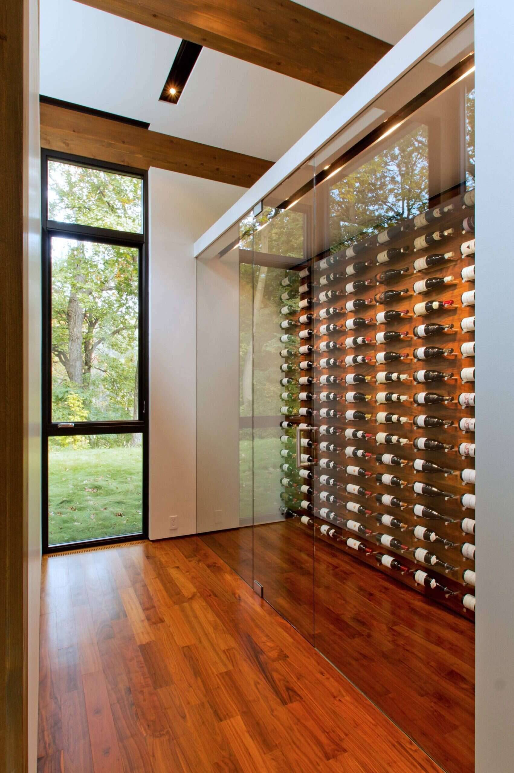 A sleek glass front wine room that displays a tidy collection in style.