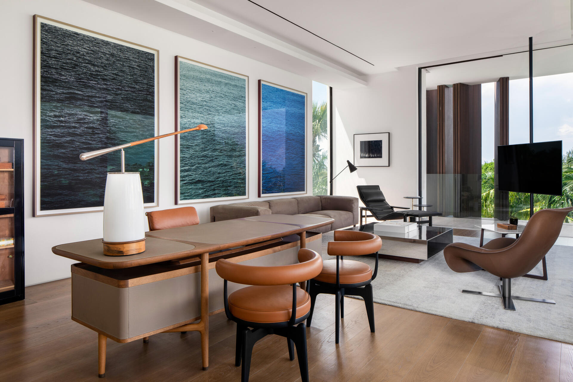 Interiors, like this home office, are filled with timber, stone, and local artwork create a warm contrast to the clean architecture.