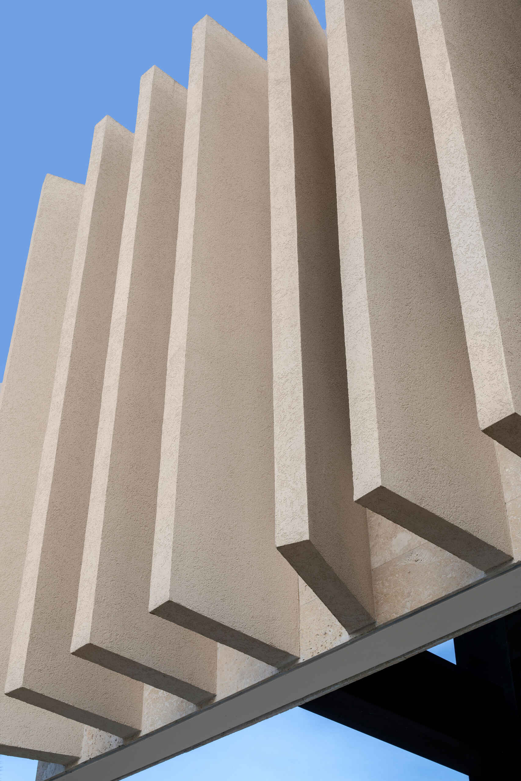 A modern island home shaped by coral stone fins and generous glazing that opens to the landscape.