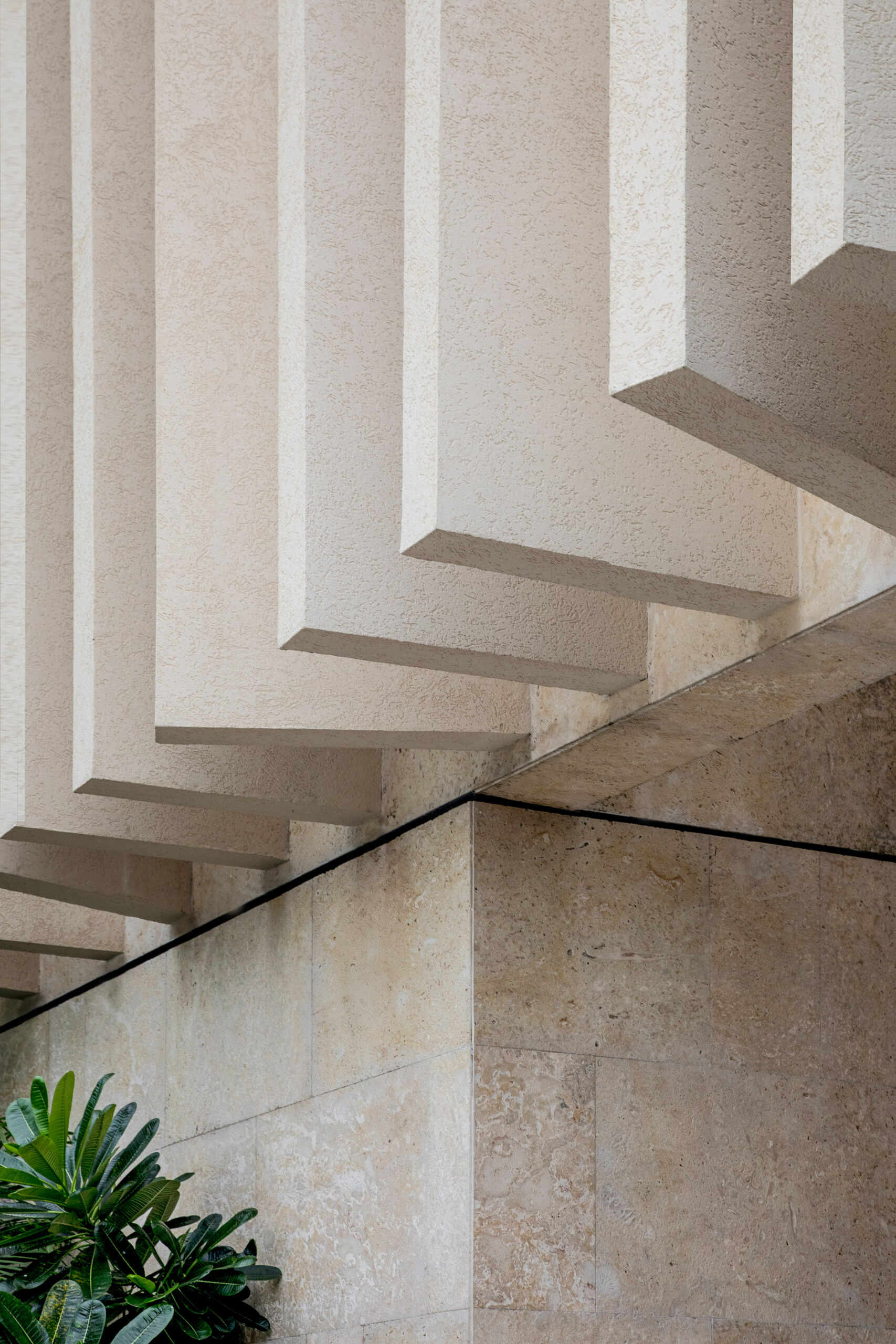 A modern island home shaped by coral stone fins and generous glazing that opens to the landscape.