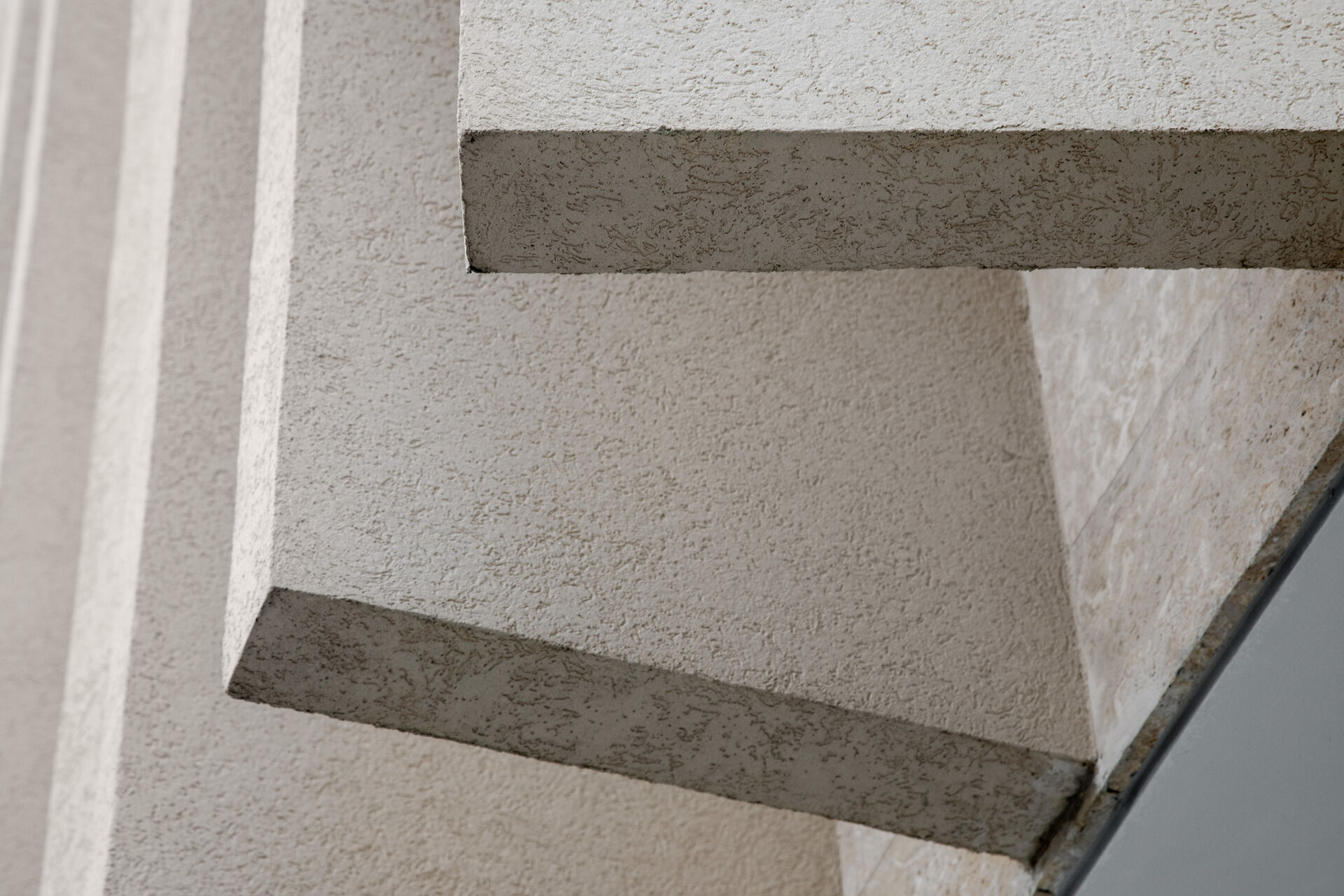 A modern island home shaped by coral stone fins and generous glazing that opens to the landscape.