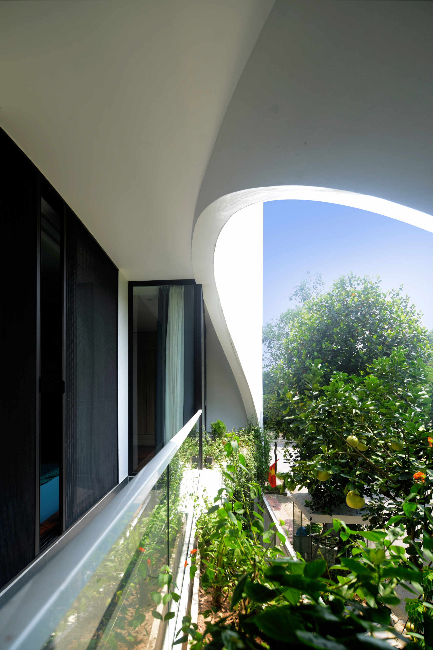 White volumes, curved cuts and filtered daylight create a facade that feels strong yet graceful, glowing softly at night.