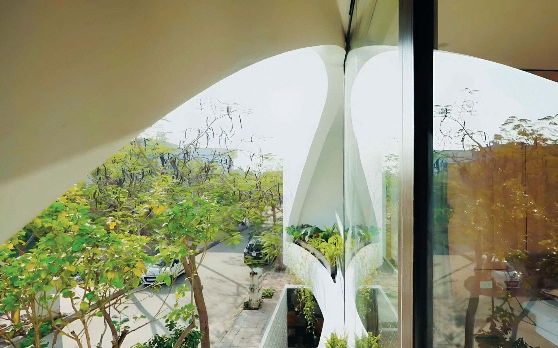 White volumes, curved cuts and filtered daylight create a facade that feels strong yet graceful, glowing softly at night.