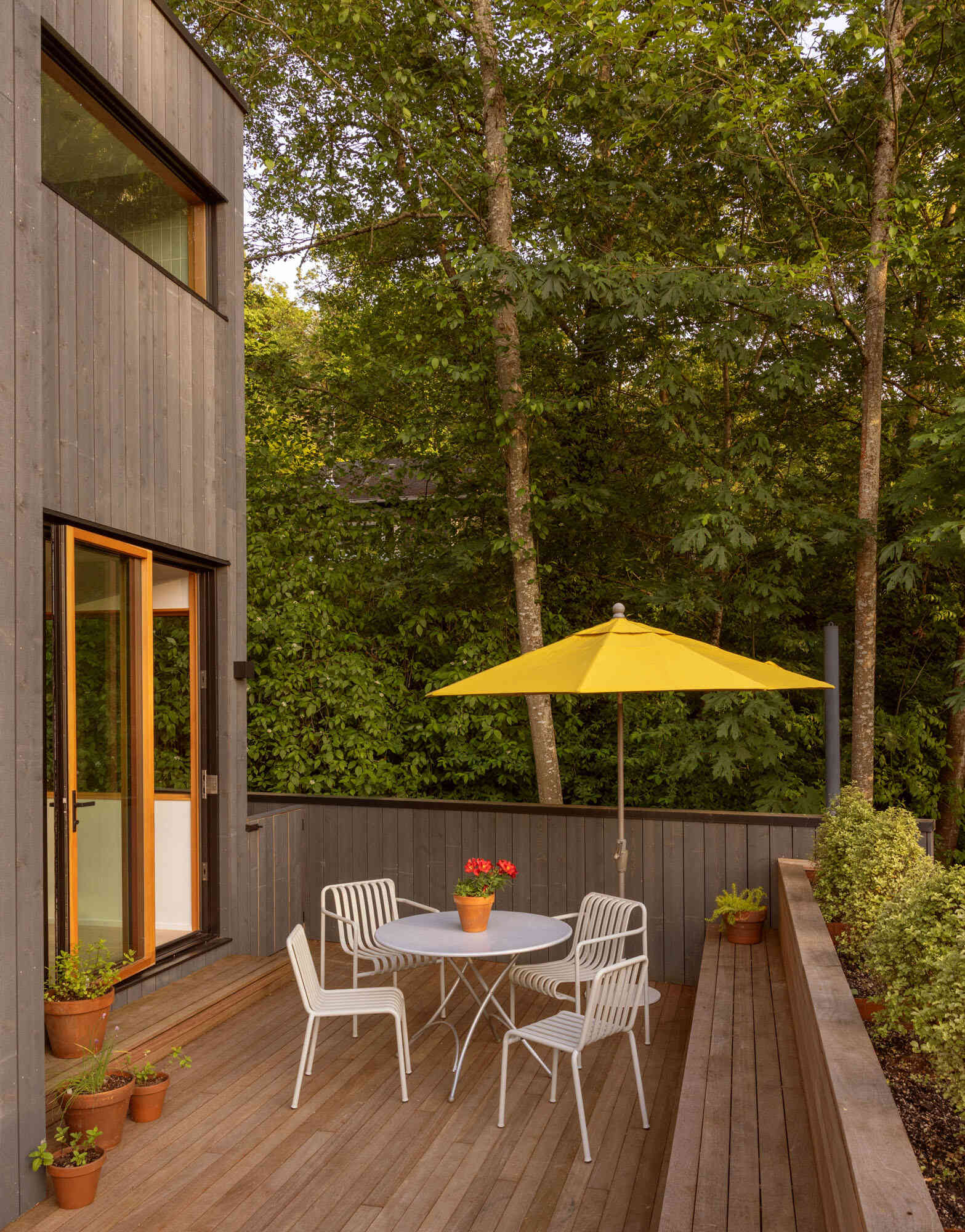 To the west, the redesigned deck becomes an outdoor extension of the main level. Batu wood decking and a custom COR-TEN planter and bench add warmth and privacy. The deck creates a direct line to the forested garden below while expanding the home’s social spaces.