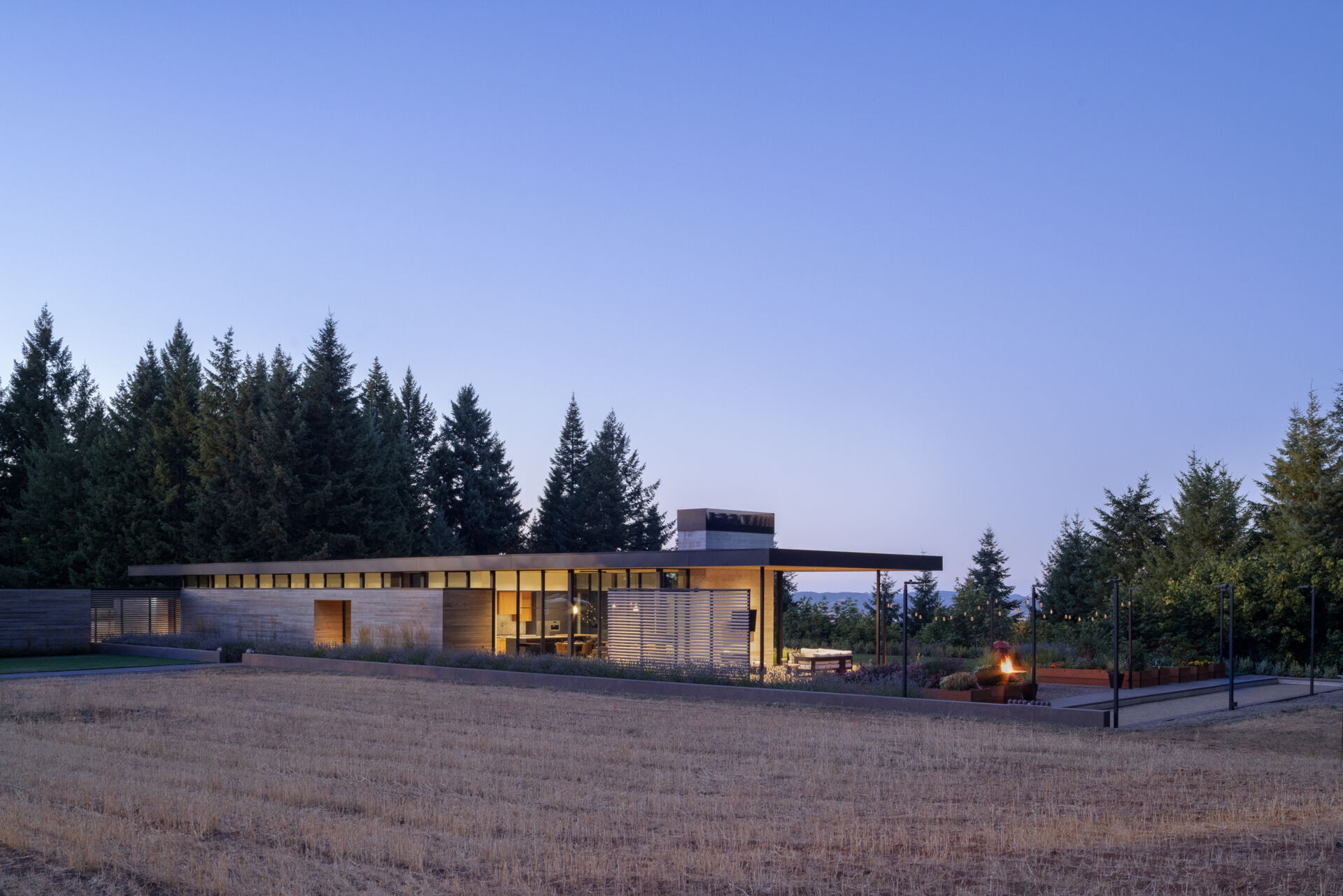 A quiet, cedar clad vineyard home emerges from the evergreens, designed with simple forms and warm minimalism that shape every room.