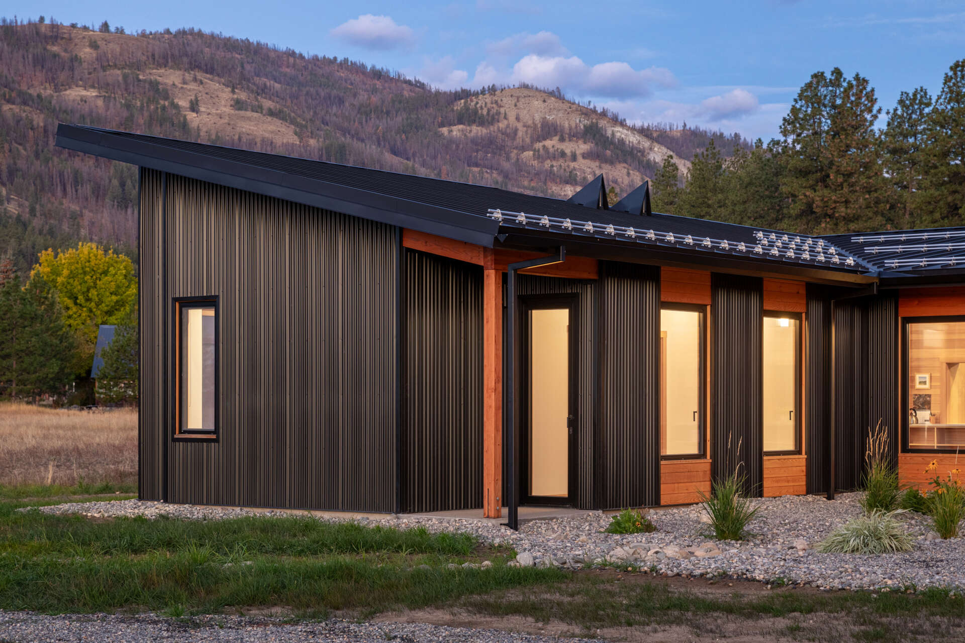 La combinación de cedro, vidrio y metal le da a la casa un aspecto natural en capas que se integra con el paisaje circundante.