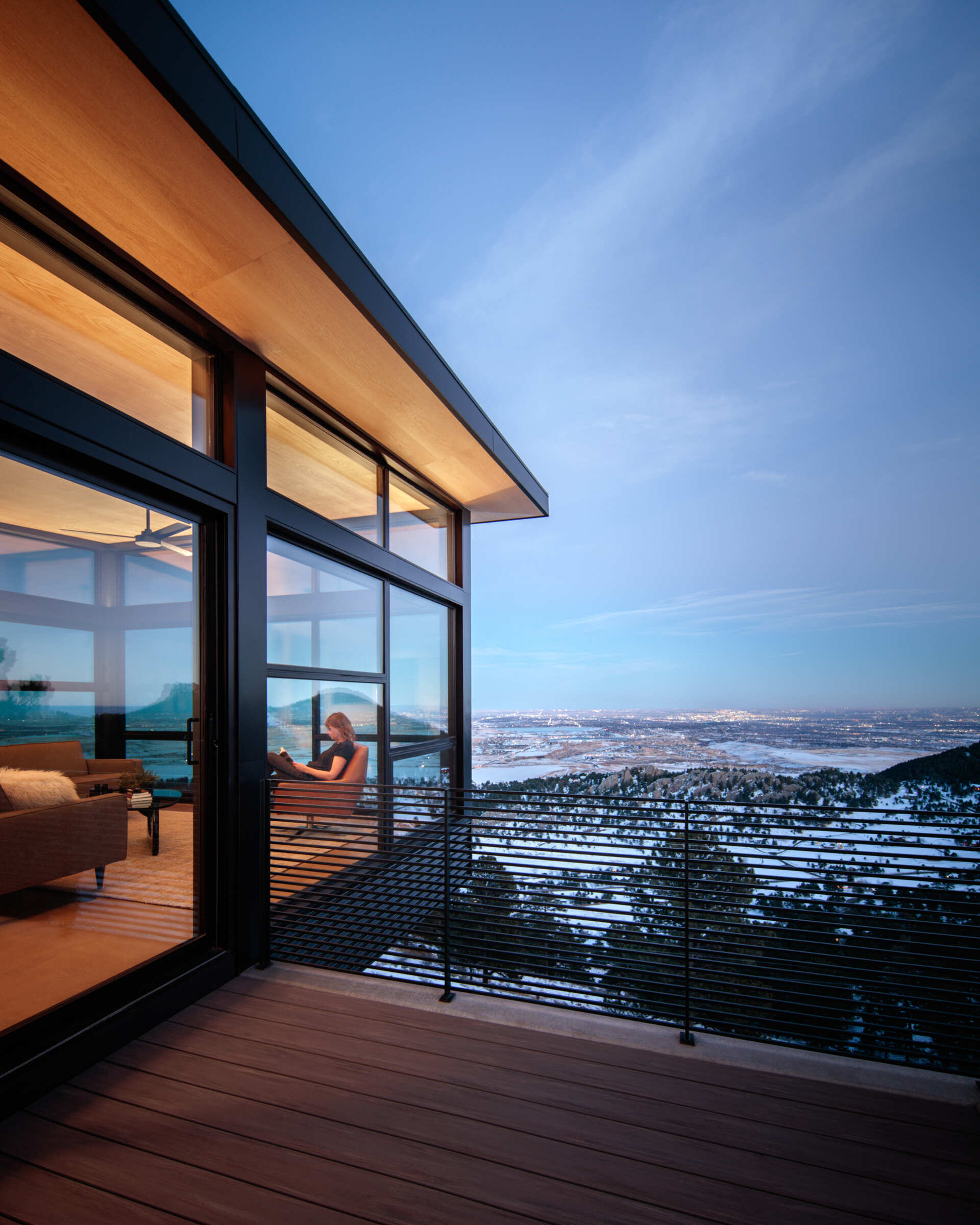 A glass encased living room that appears to float above the landscape. Floor to ceiling windows pull in mountain views and shift with light throughout the day.