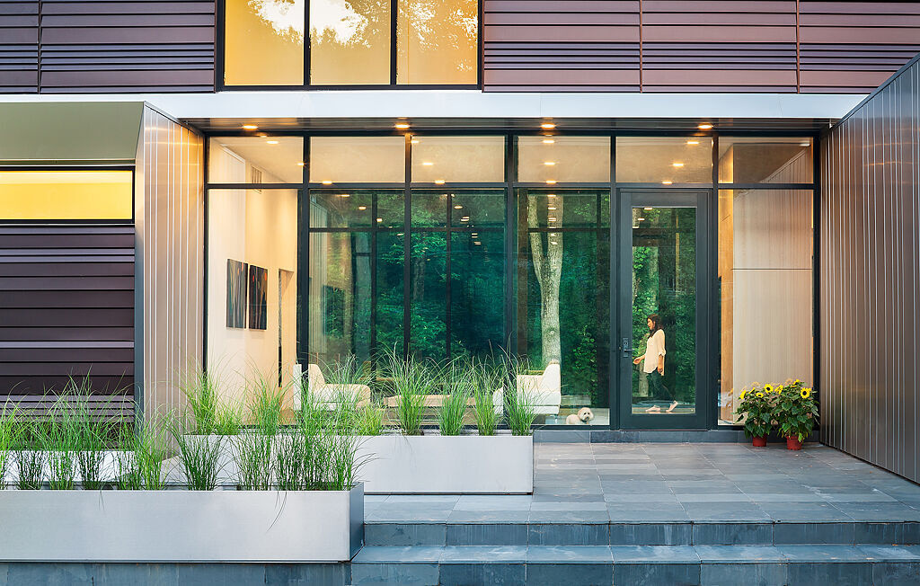 Step inside Bridge House in Virginia, where glass walls and steel details create a welcoming entry that blurs the line between home and forest.