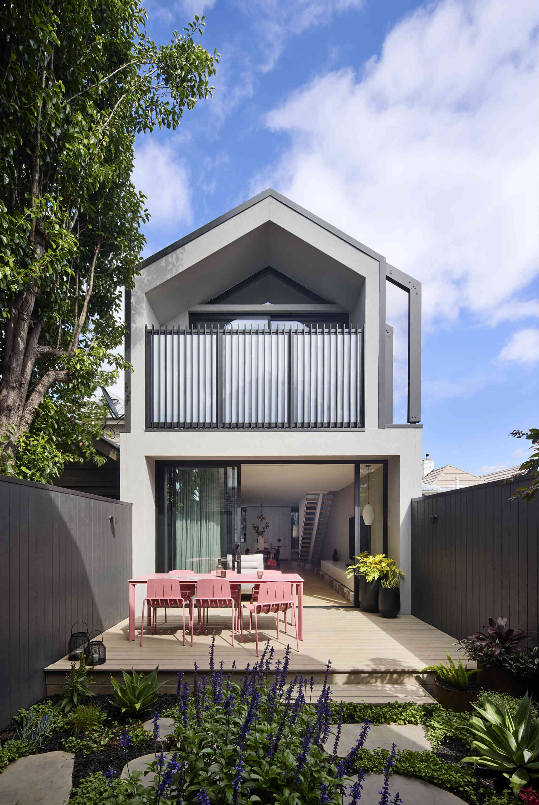 At the rear, the extension opens fully to the garden. Large sliding doors shift the living area into the outdoor terrace, creating a smooth connection that increases the usable footprint.