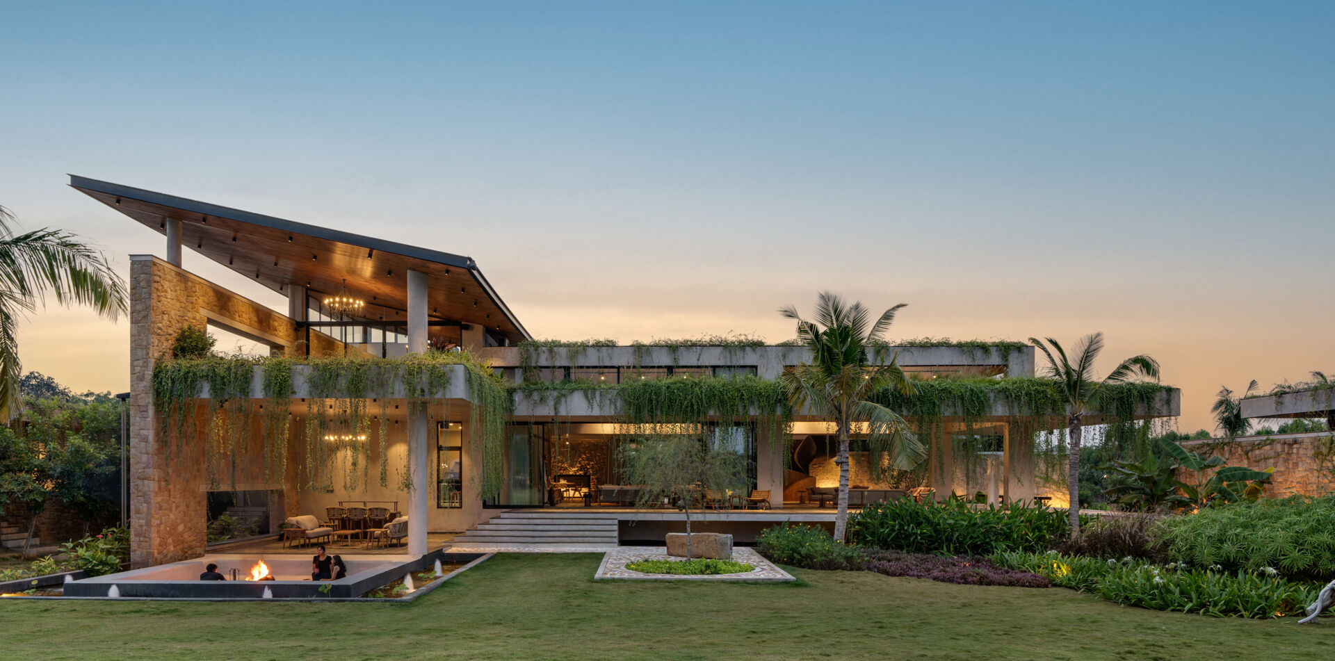 Soft exterior lighting on this modern house highlights the stone walls and enhances the floating effect at night.
