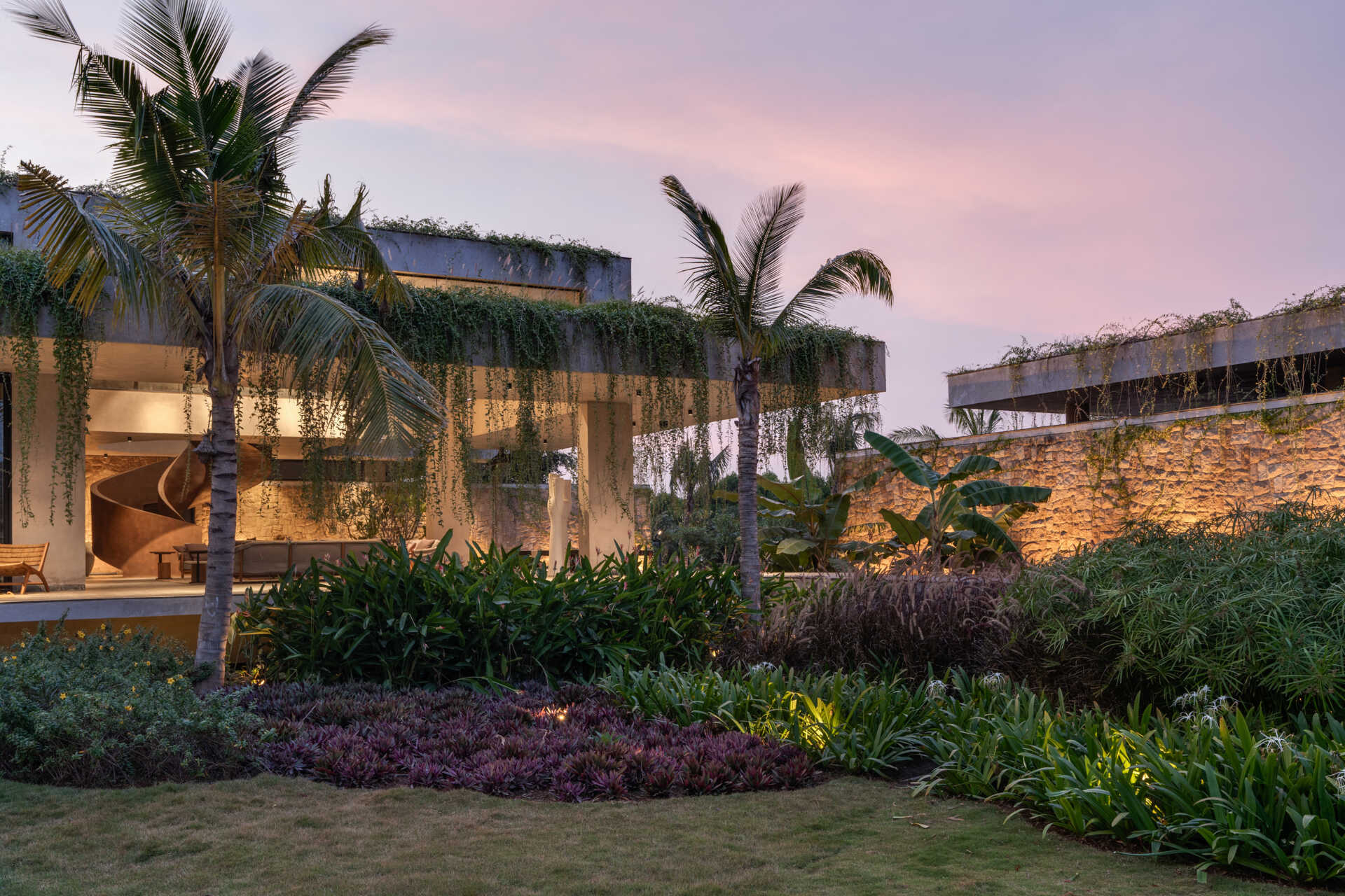 Soft exterior lighting on this modern house highlights the stone walls and enhances the floating effect at night.