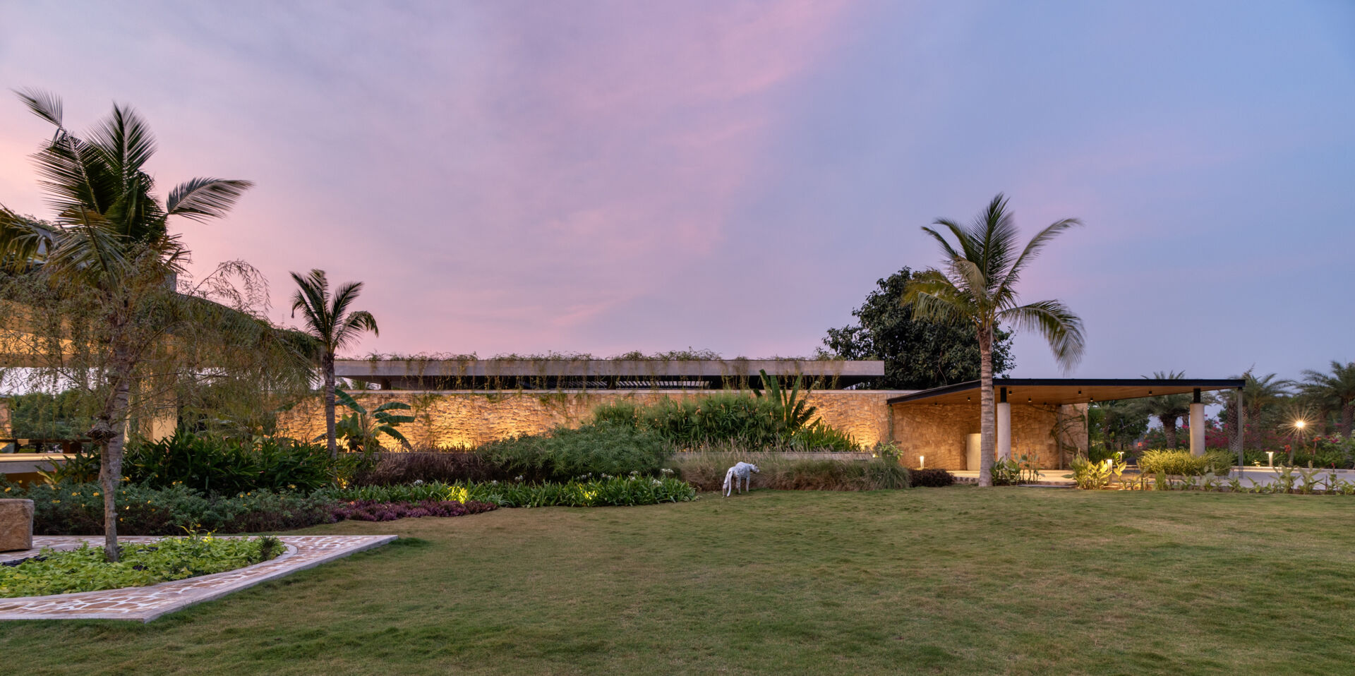 Soft exterior lighting on this modern house highlights the stone walls and enhances the floating effect at night.