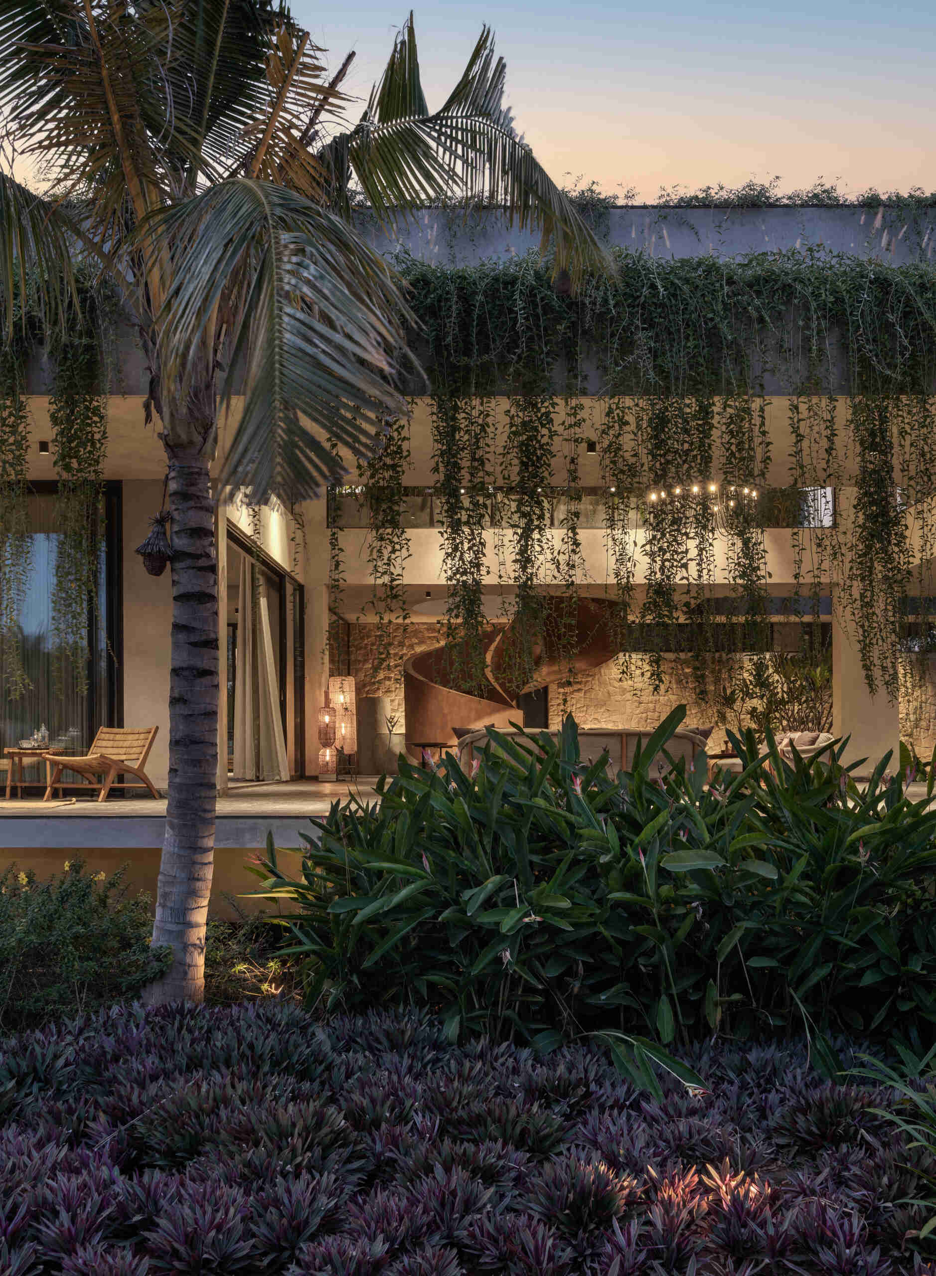 Soft exterior lighting on this modern house highlights the stone walls and enhances the floating effect at night.