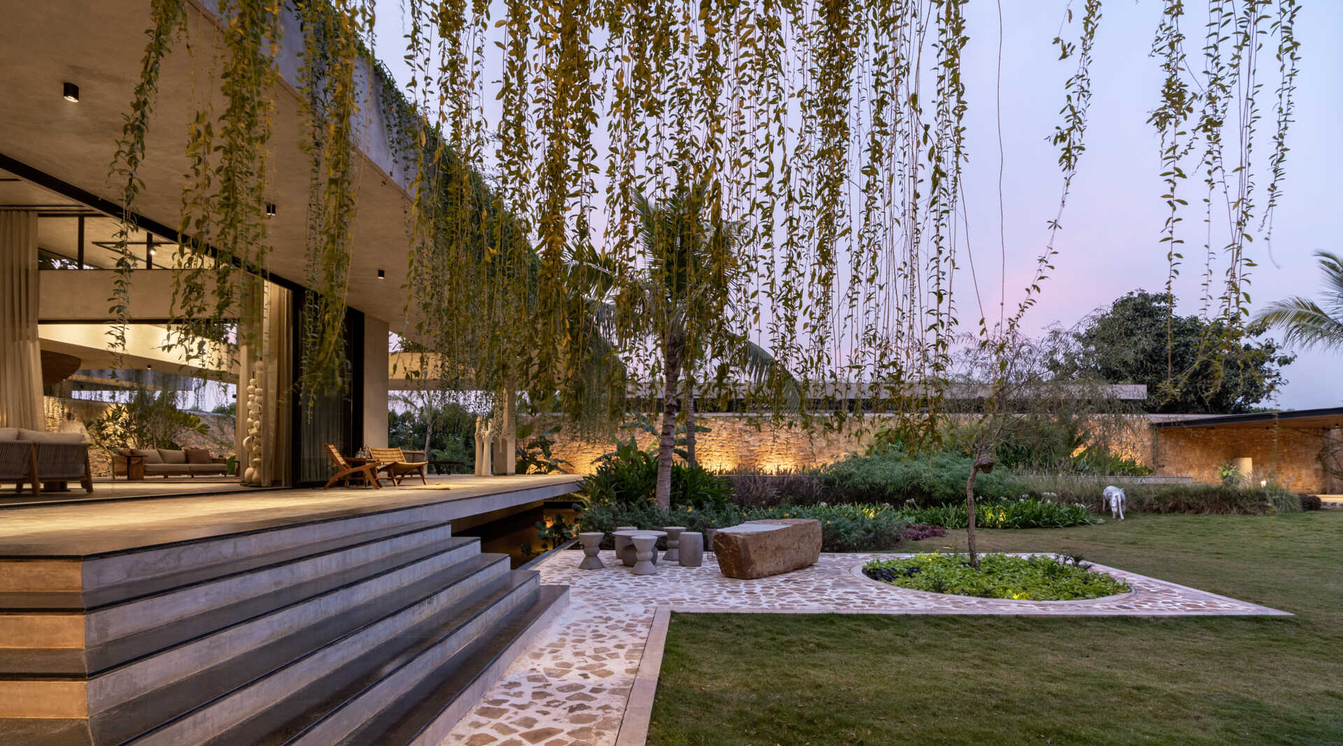 Soft exterior lighting on this modern house highlights the stone walls and enhances the floating effect at night.