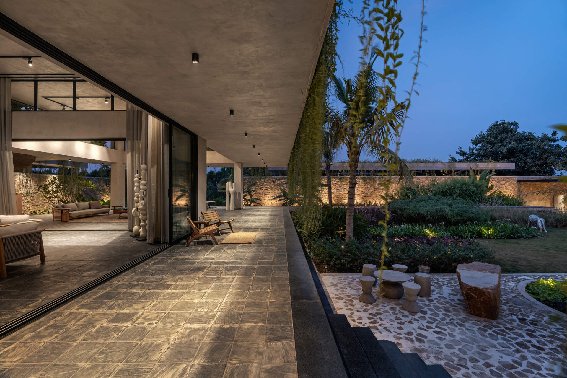 Soft exterior lighting on this modern house highlights the stone walls and enhances the floating effect at night.