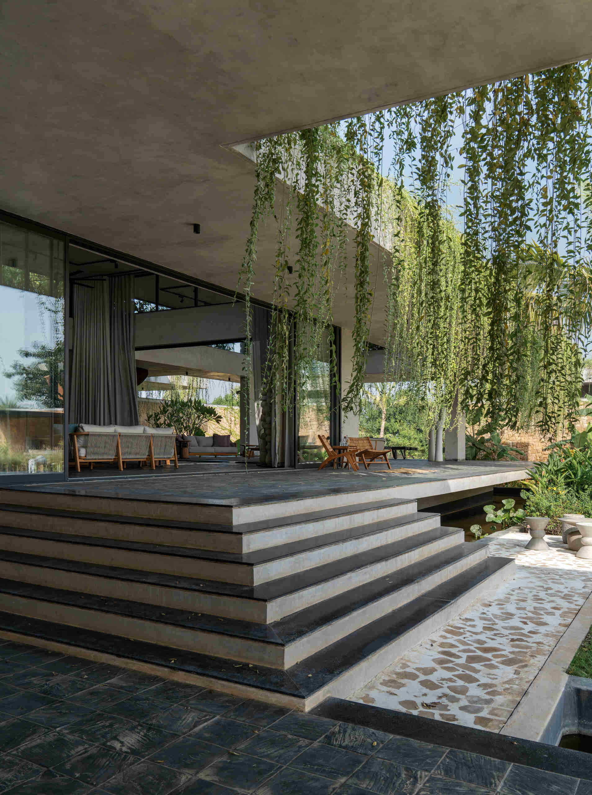 Floating walkways and hanging plants soften the architecture of this modern house and connect it to nature.