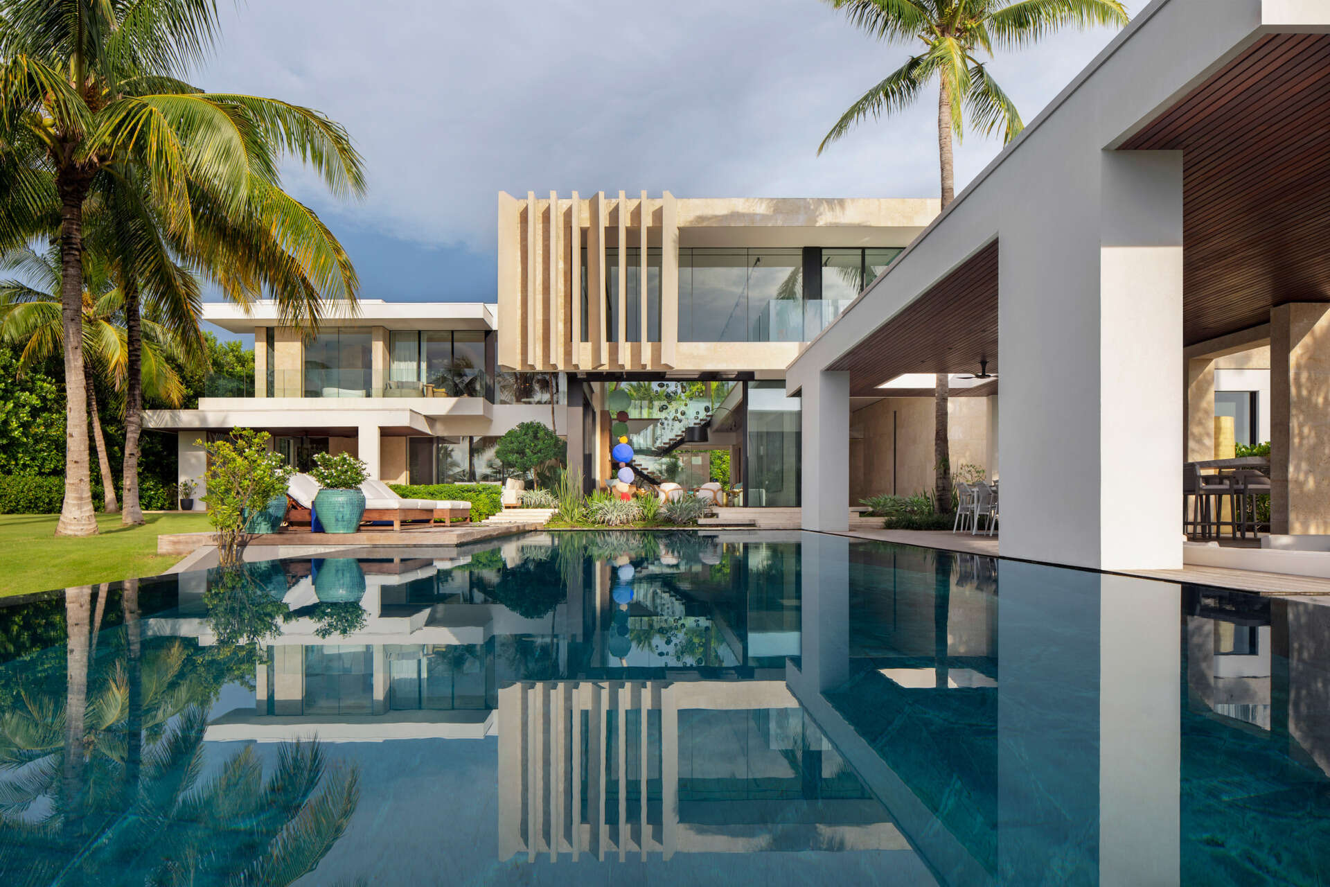 A tropical home with outdoor rooms and an infinity pool that blends naturally with the canal and surrounding greenery.