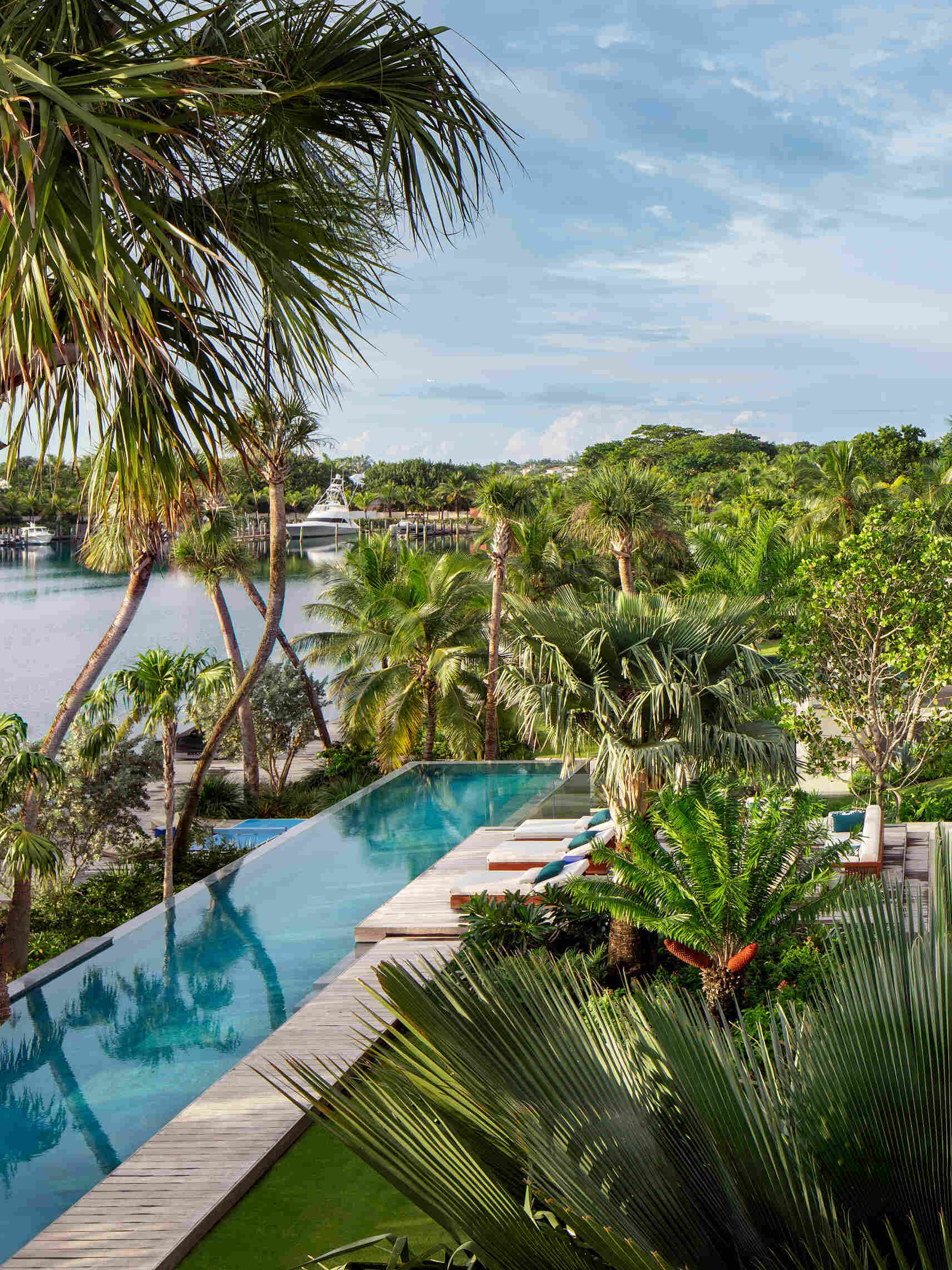 A tropical home with outdoor rooms and an infinity pool that blends naturally with the canal and surrounding greenery.