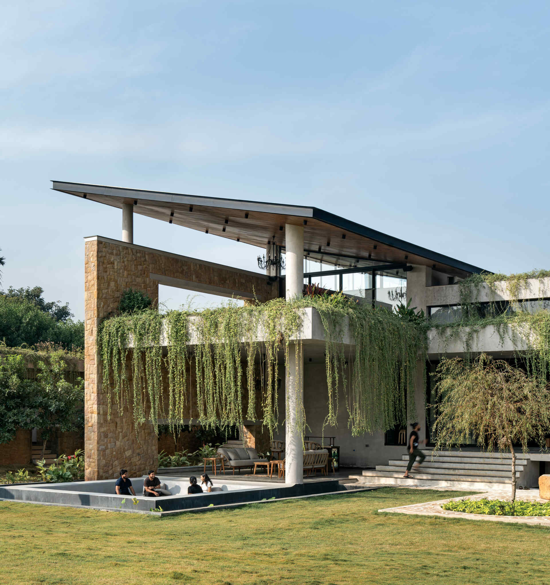 A sunken lounge set into the landscape creates a cozy gathering spot beside the garden.