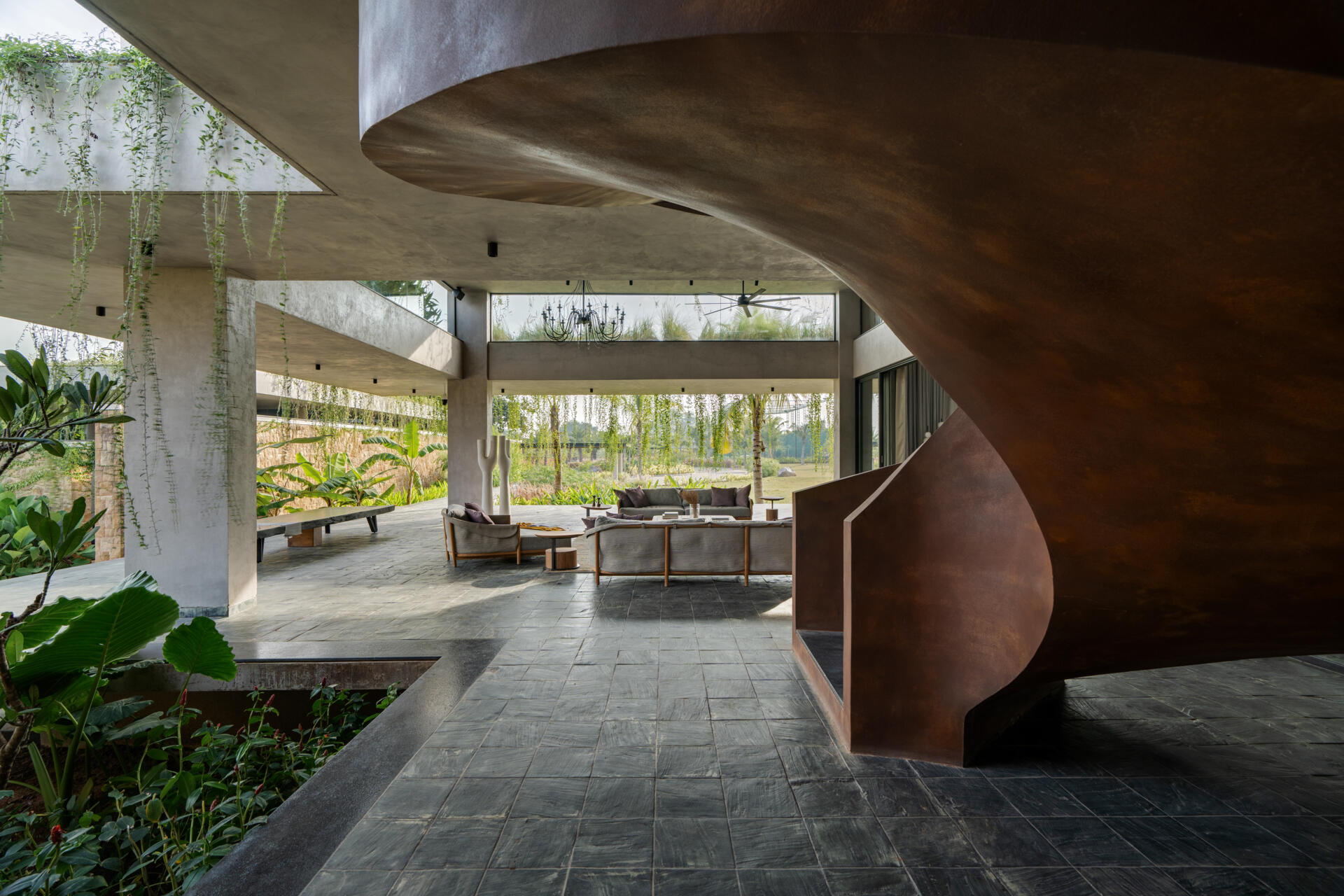 A sculptural spiral staircase contrasts with the floating architecture around it, anchoring the space.