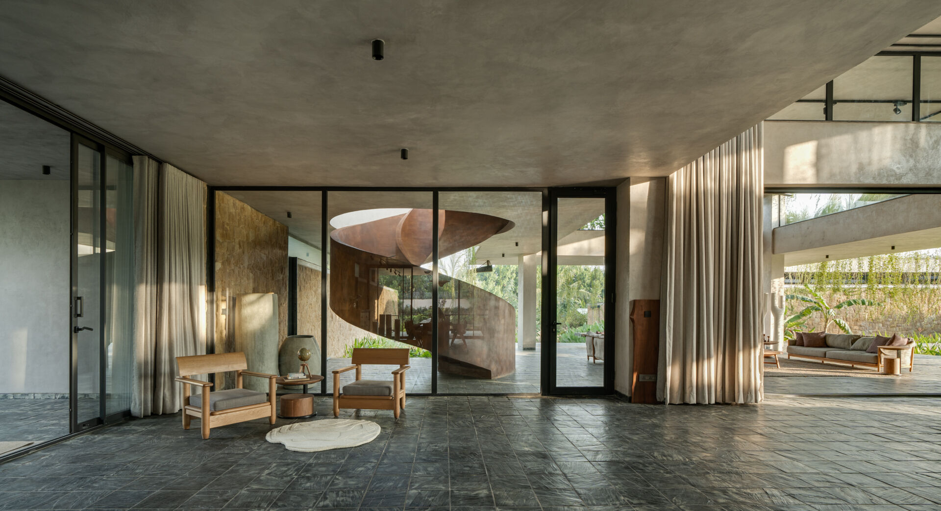 A sculptural spiral staircase contrasts with the floating architecture around it, anchoring the space.