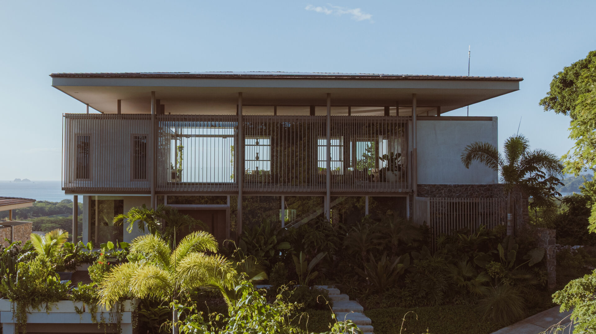 A hillside villa in Costa Rica with a cantilevered swimming pool, is shaped by terraces and light, designed for calm indoor and outdoor living.