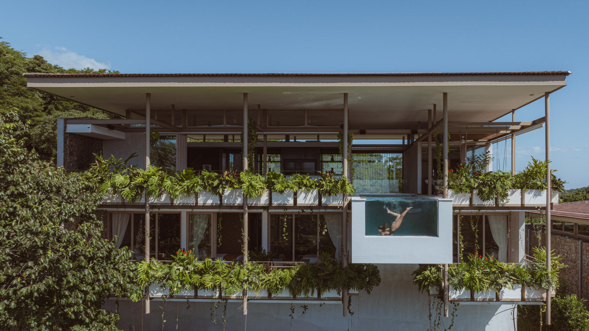 A hillside villa in Costa Rica with a cantilevered swimming pool, is shaped by terraces and light, designed for calm indoor and outdoor living.