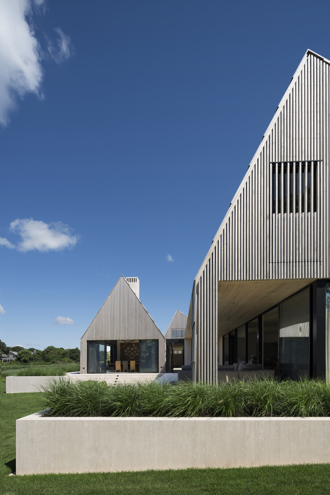 Las tejas de cedro de gran tamaño y las elegantes mamparas de cedro le dan a esta casa costera un aspecto cálido y texturizado.